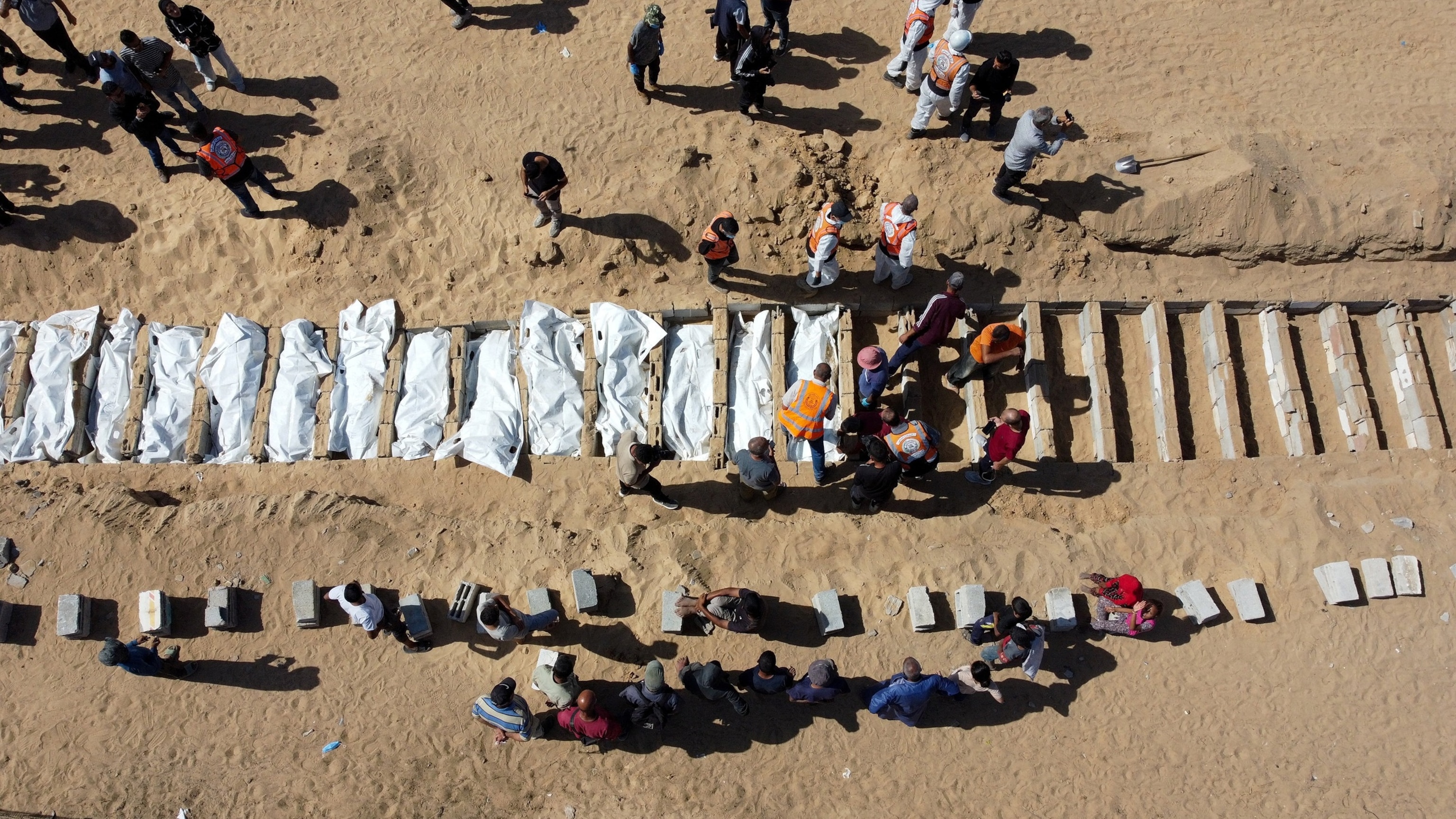 PHOTO: A drone view shows people gathering to bury unidentified bodies of Palestinians, who had been held in Israel during the war, at a mass burial site after they were handed over by Israel, in Deir Al-Balah, Oct. 22, 2025.