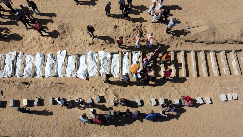 PHOTO: A drone view shows people gathering to bury unidentified bodies of Palestinians, who had been held in Israel during the war, at a mass burial site after they were handed over by Israel, in Deir Al-Balah, Oct. 22, 2025.