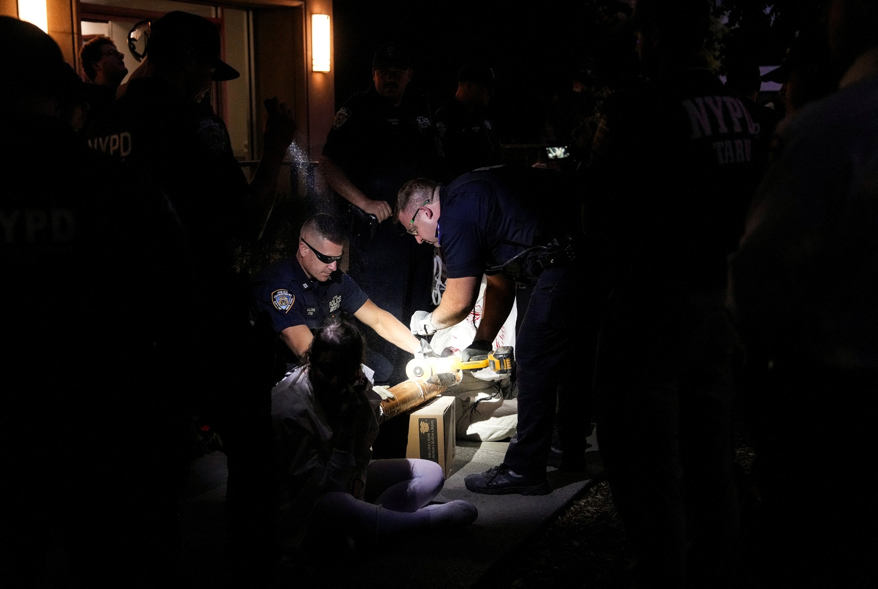PHOTO: New York Police Department officers cut a device used by people blocking the Brooklyn side of the Brooklyn Bridge to protest Israel's military action in Gaza, in New York City, Oct. 2, 2025.