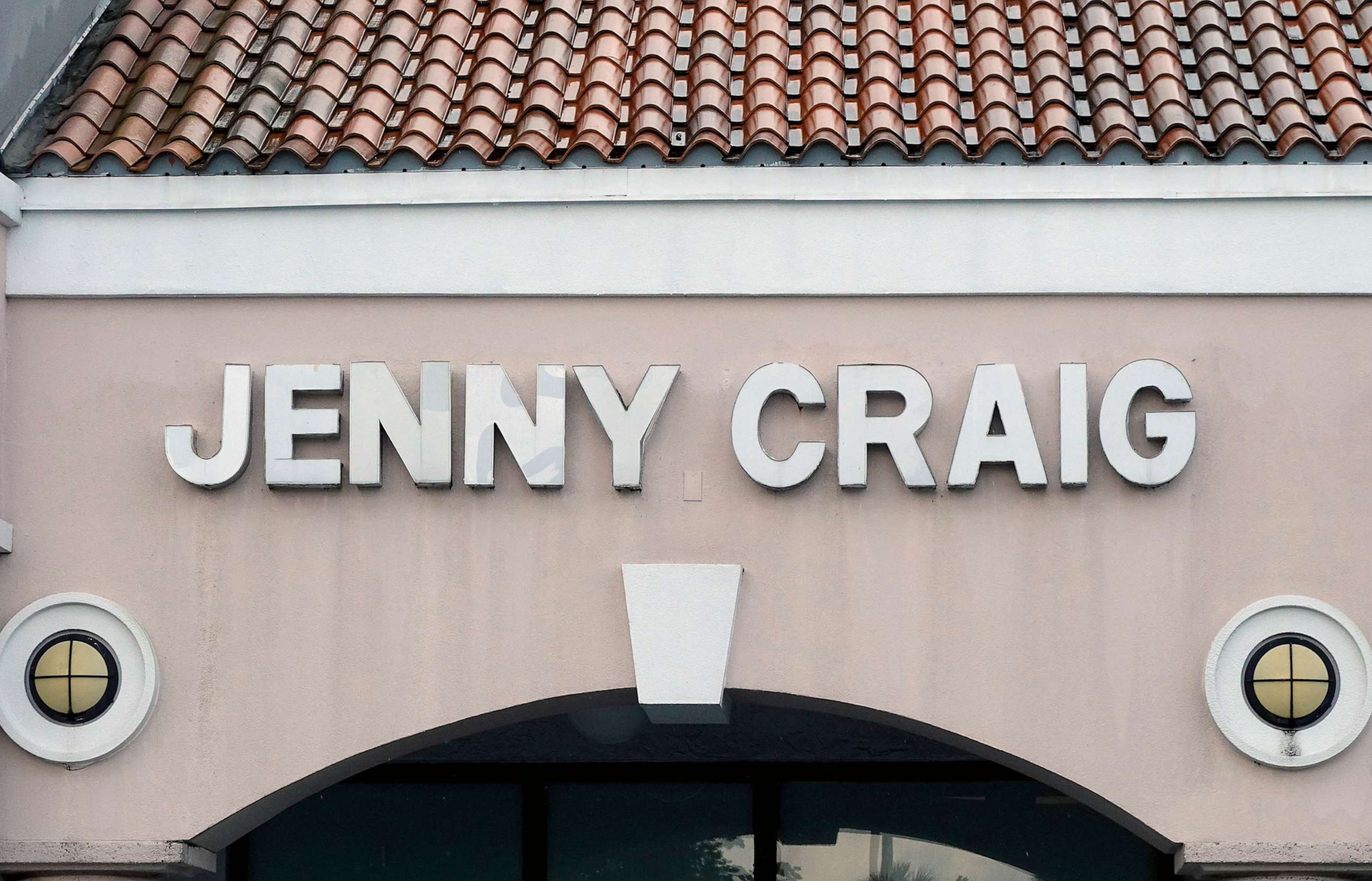 PHOTO: A Jenny Craig sign hangs on the wall outside of the weight loss store, April 28, 2023 in Miami.