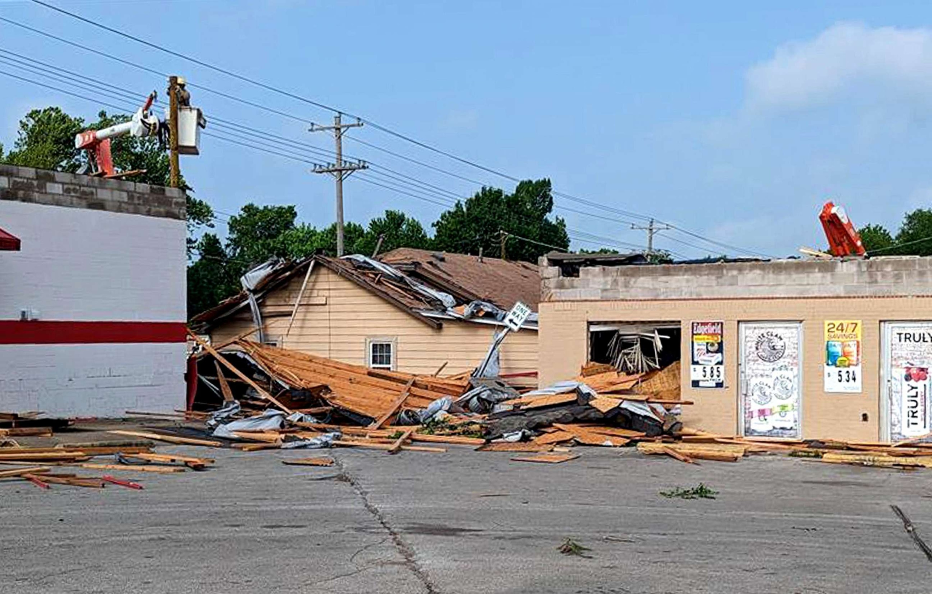 PHOTO: Workers repair lines over damaged buildings following storms and tornados in Noble, Okla., on Friday, May 12, 2023, after tornados hit the area on Thursday evening.