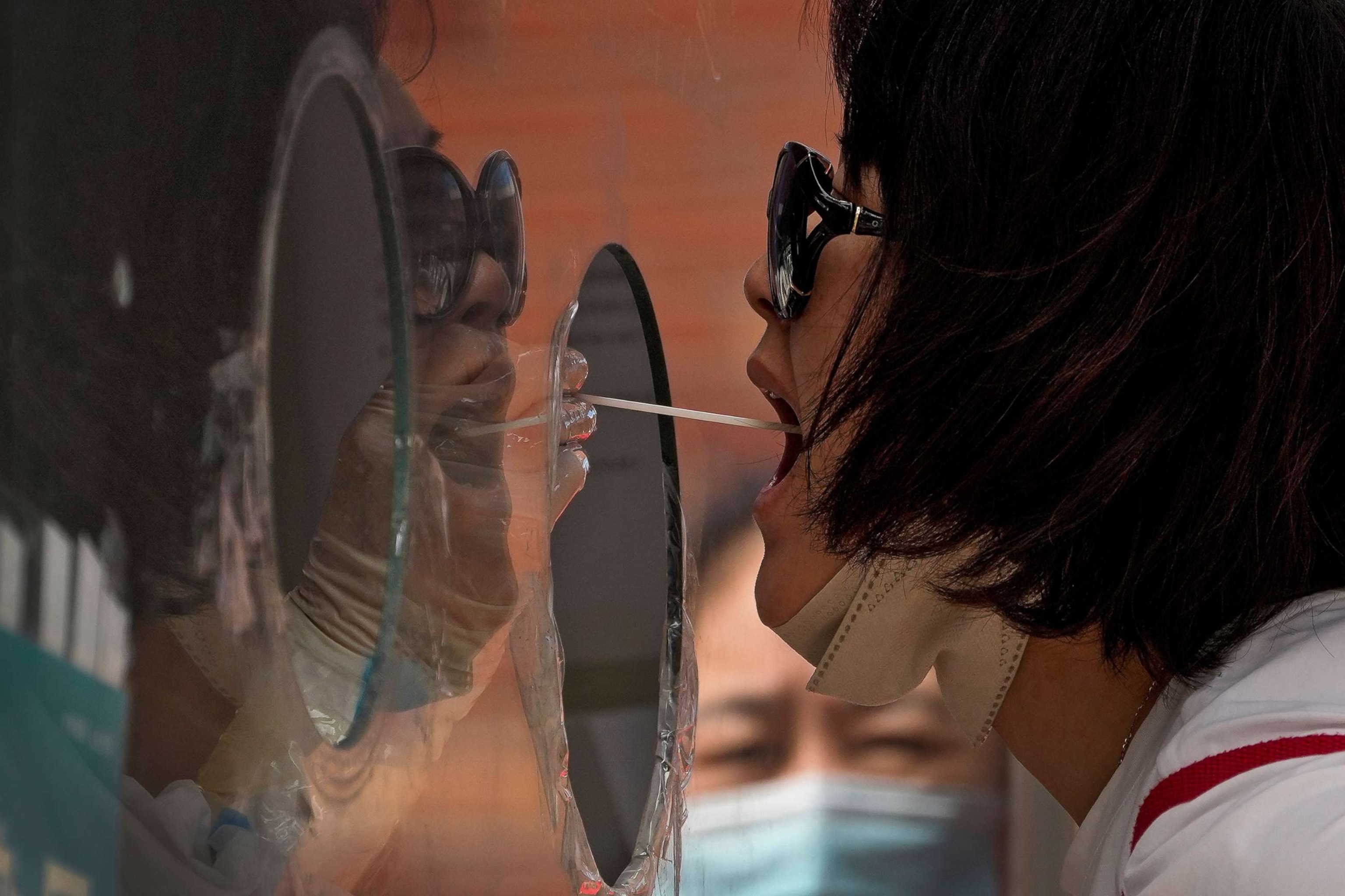 PHOTO: A woman gets her routine COVID-19 throat swab at a coronavirus testing site in Beijing, Aug. 23, 2022.