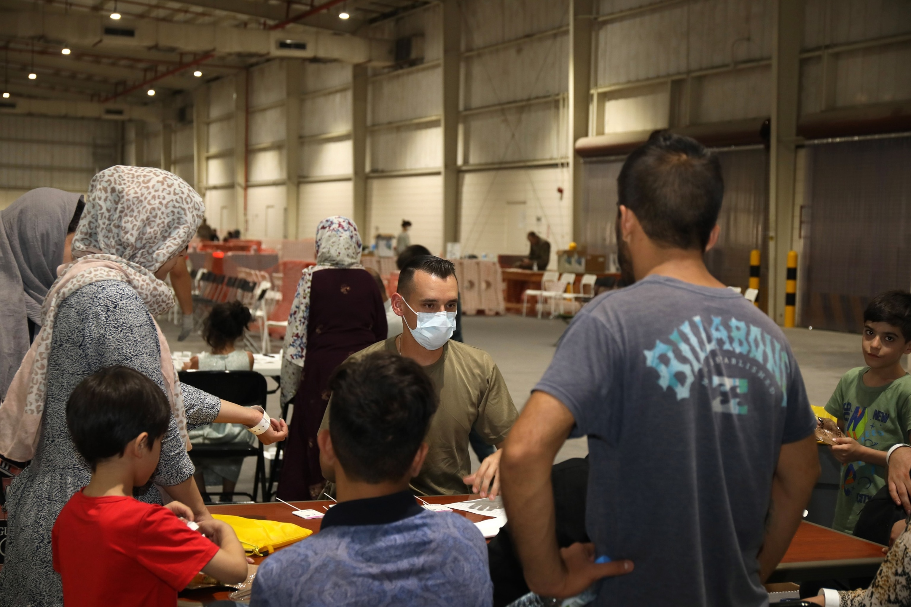 PHOTO: In this Aug. 20, 2021, file photo provided by the U.S. Army, combat medic Sgt. Wyatt Ryser with the 811th Hospital Center gives a Covid-19 briefing to an Afghan family at Camp As Sayliyah in Doha, Qatar.