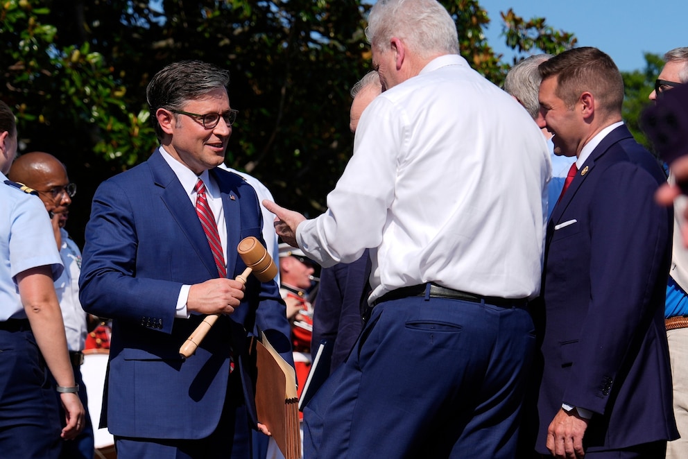 PHOTO: House Speaker Mike Johnson holds a gavel as he attends a Fourth of July celebration on the South Lawn at the White House, July 4, 2025, in Washington, D.C., as he talks with Rep. Tom Emmer, Rep. Steve Scalise, and others.