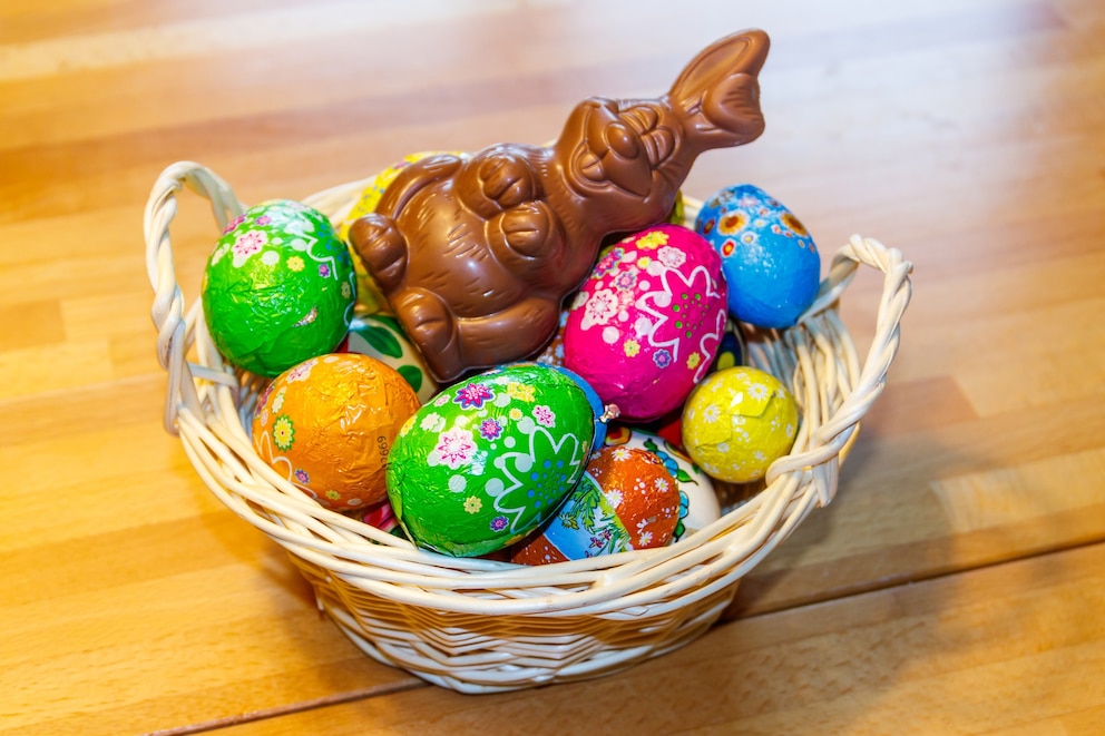 PHOTO: Basket with Easter eggs and Easter bunny on wooden table