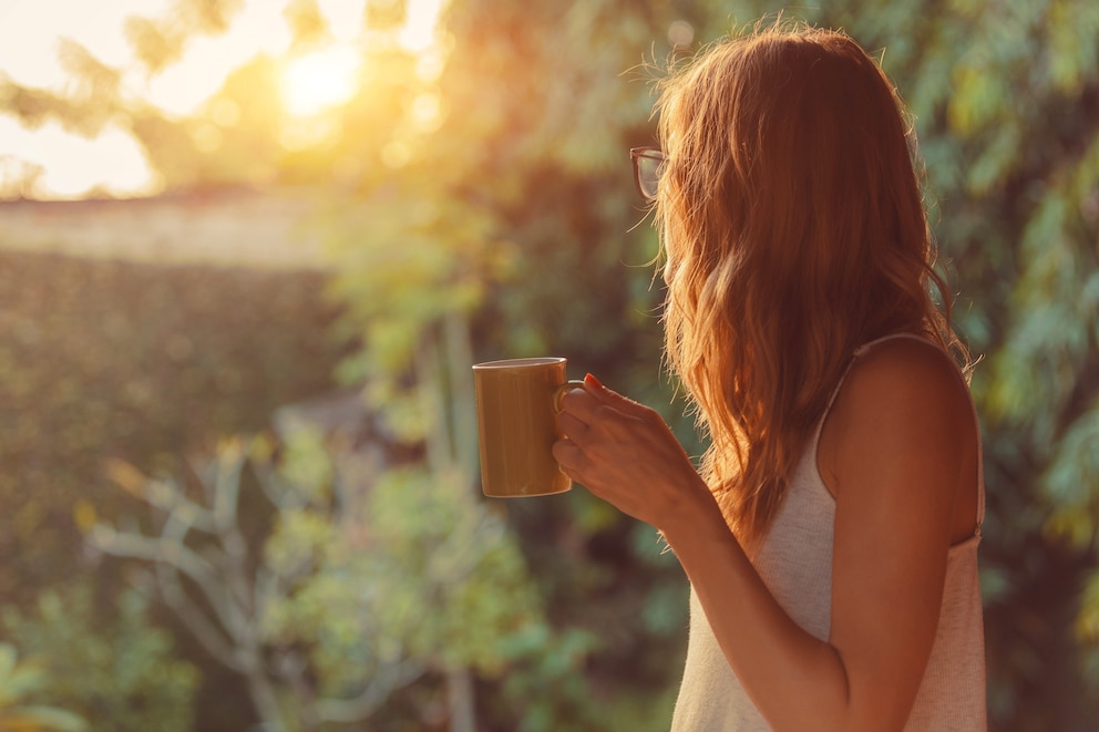 PHOTO: woman drinking from mug on porch