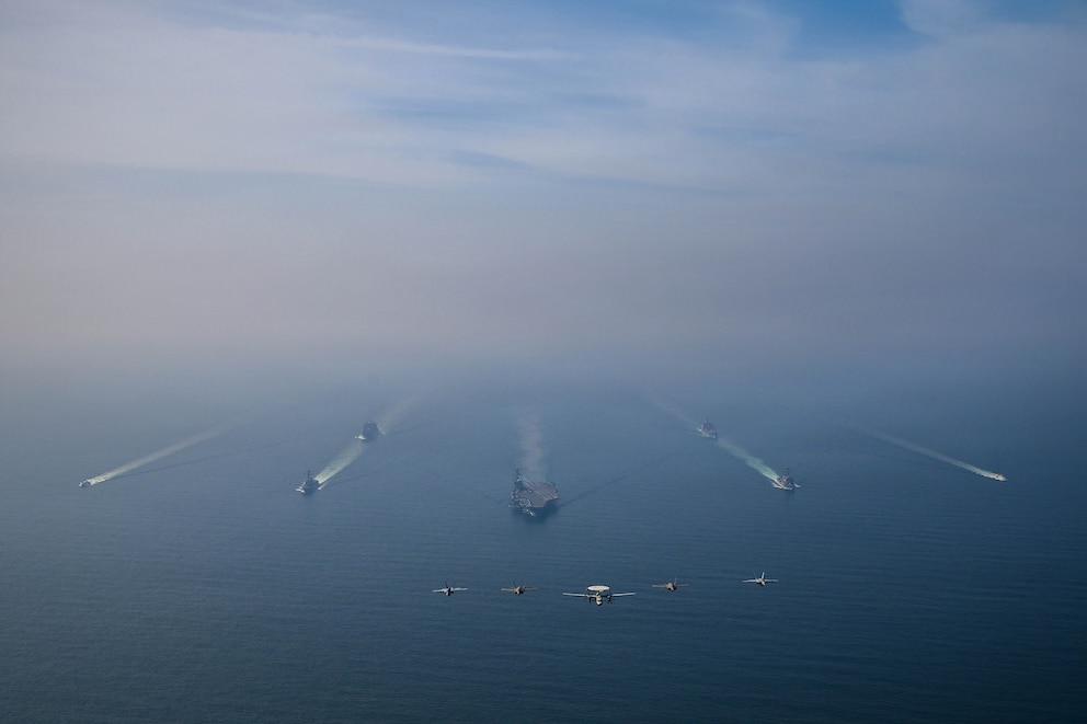 PHOTO: USS Abraham Lincoln carrier strike group sails in formation in the Arabian Sea while aircraft, from Carrier Air Wing 9, fly overhead, Feb. 6, 2026. 