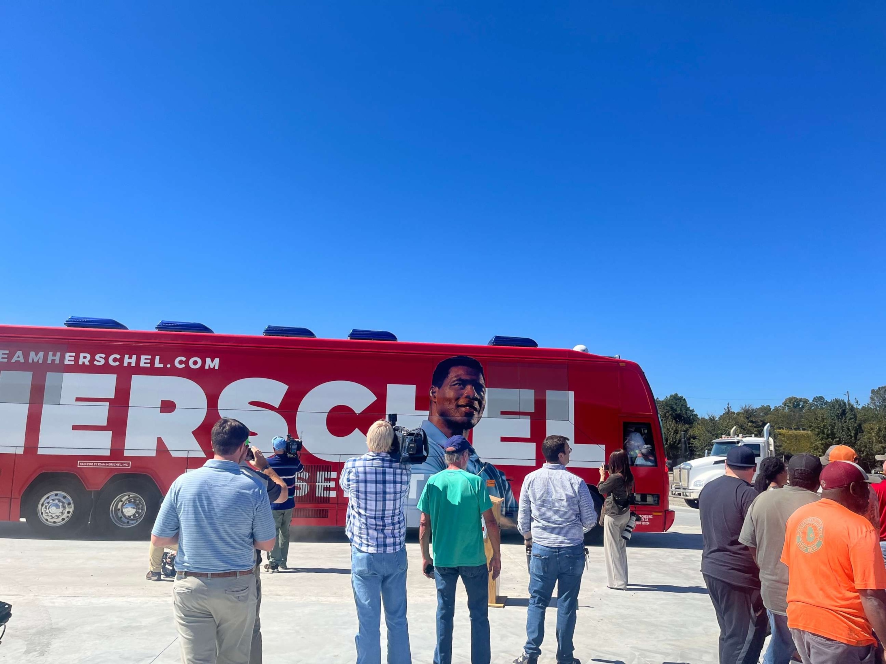 PHOTO: Herschel Walker voters gather outside his campaign bus at a stop in Wadley, Ga., Oct. 6, 2022.