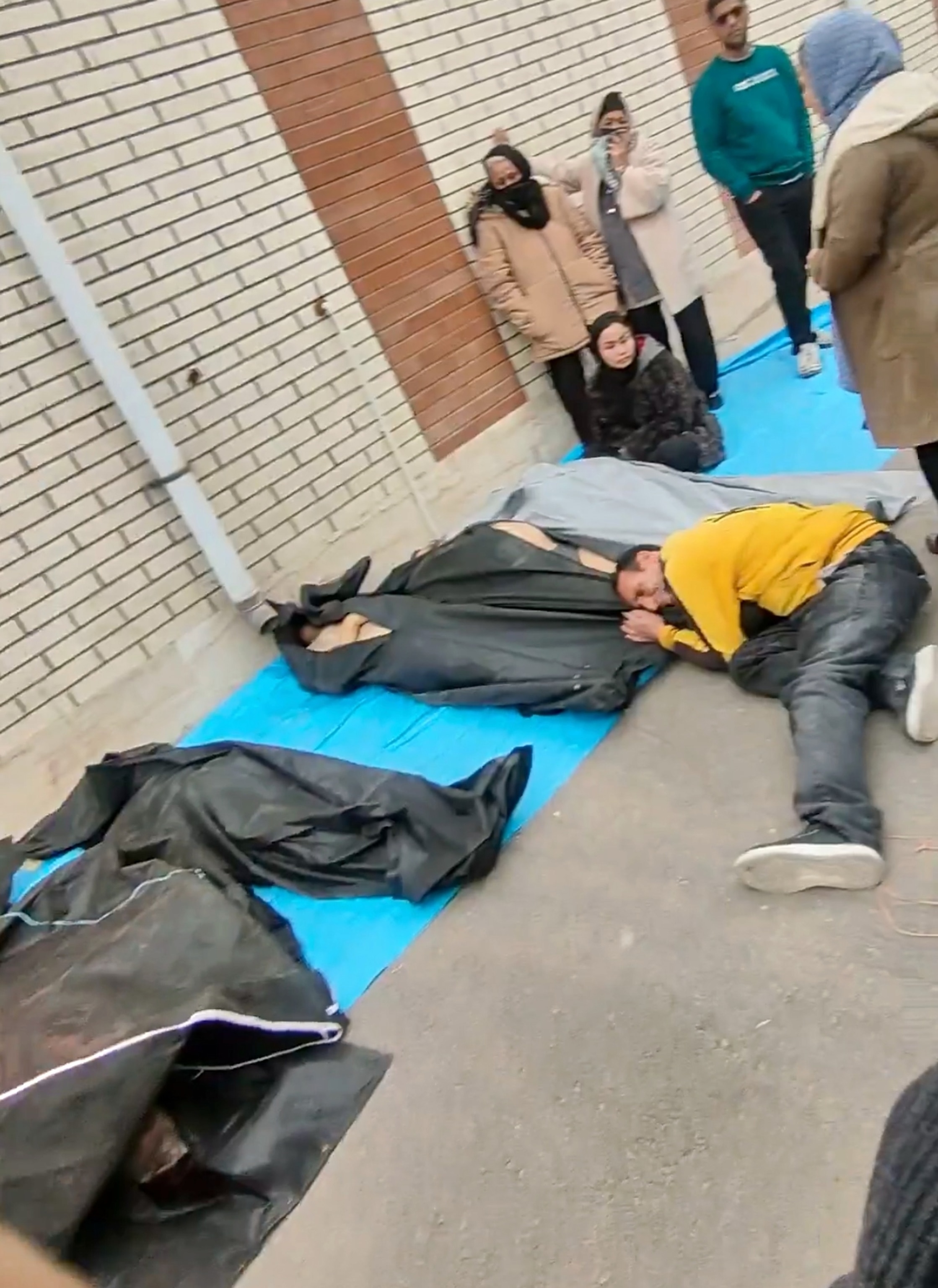 PHOTO: This image from video taken between Jan. 9 and Jan. 11, 2026 shows mourners next to the bodies of people who were brought from different locations, outside a morgue in Kahrizak, in Iran's Tehran province, after a crackdown on protests.