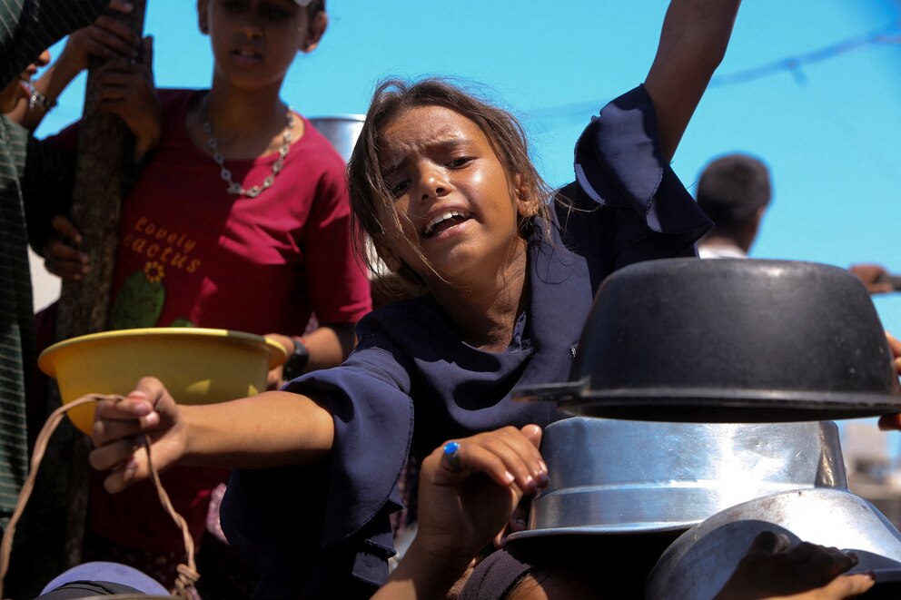 PHOTO: Palestinians wait to receive food from a charity kitchen, amid a hunger crisis, in Khan Younis