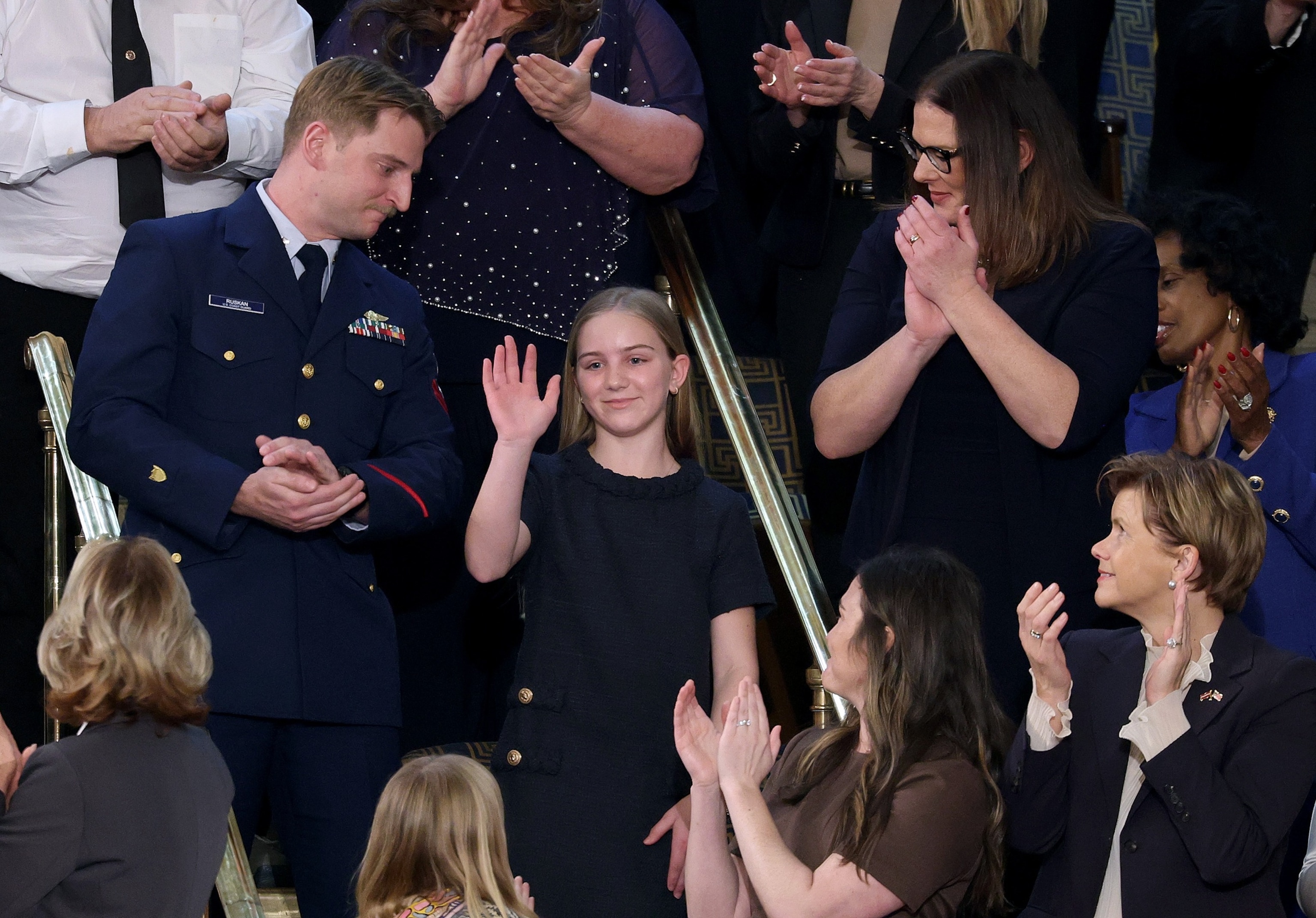PHOTO: U.S. Coast Guard Petty Officer 3rd Class Scott Ruskan, with camper Milly Cate McClymond whom he saved during the Texas floods, is honored as President Donald Trump during his State of the Unio, February 24, 2026, in Washington.