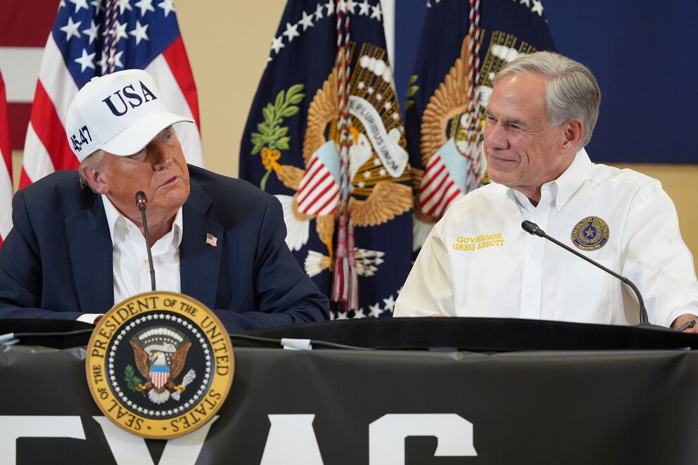 PHOTO: President Donald Trump, left, speaks as Texas Gov. Greg Abbott listens during a roundtable discussion in Kerrville, Texas, during a tour to observe flood damage, July 11, 2025.
