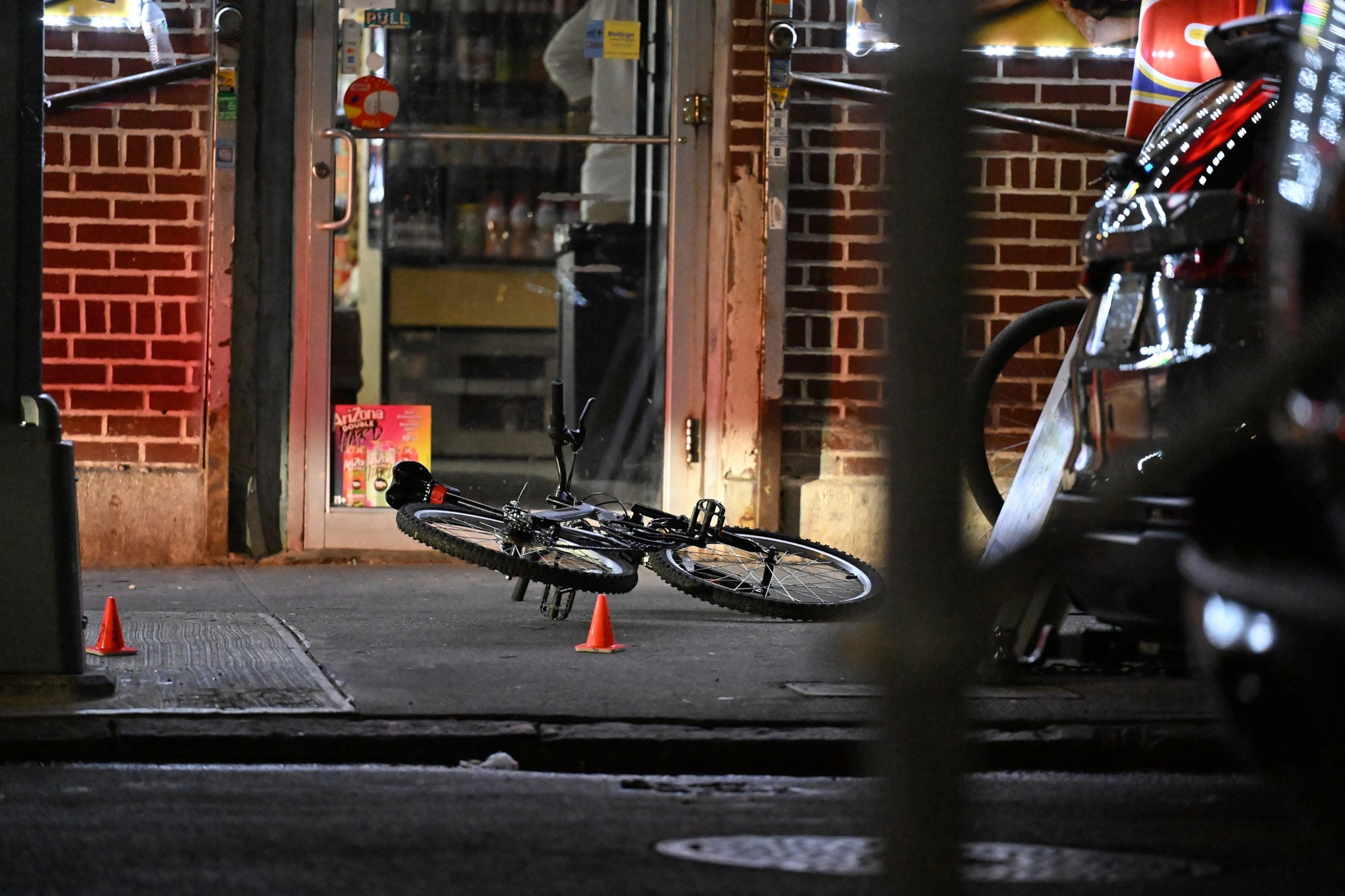 PHOTO: New York City police officers investigate the scene where 12-year-old Jacob Freytes, the son of a retired NYPD detective sergeant, was killed after being hit by a stray bullet while riding his bike, July 25, 2026, in front of a bodega. 