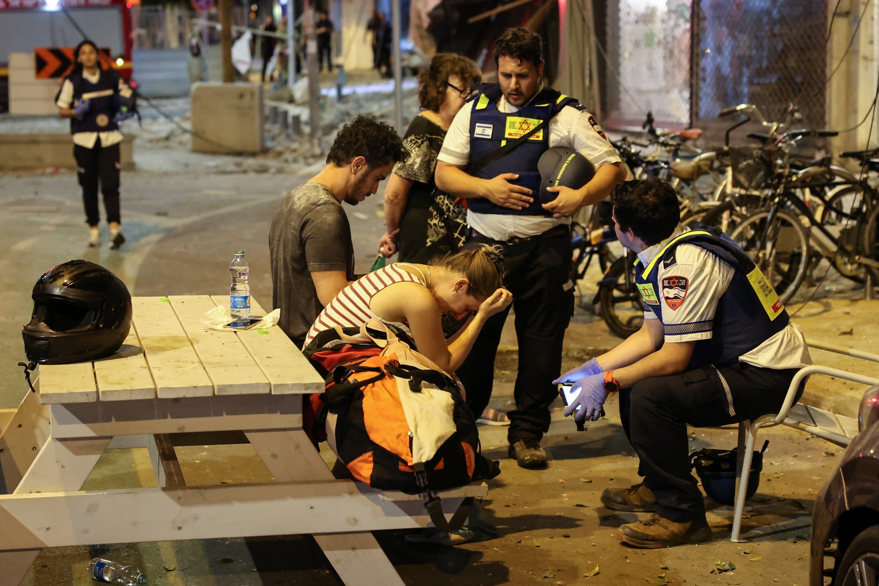 PHOTO: A young woman reacts as she speaks to Israeli rescuers in Tel Aviv, after a was hit by a rocket fired by Palestinian militants from the Gaza Strip, Oct. 7, 2023.