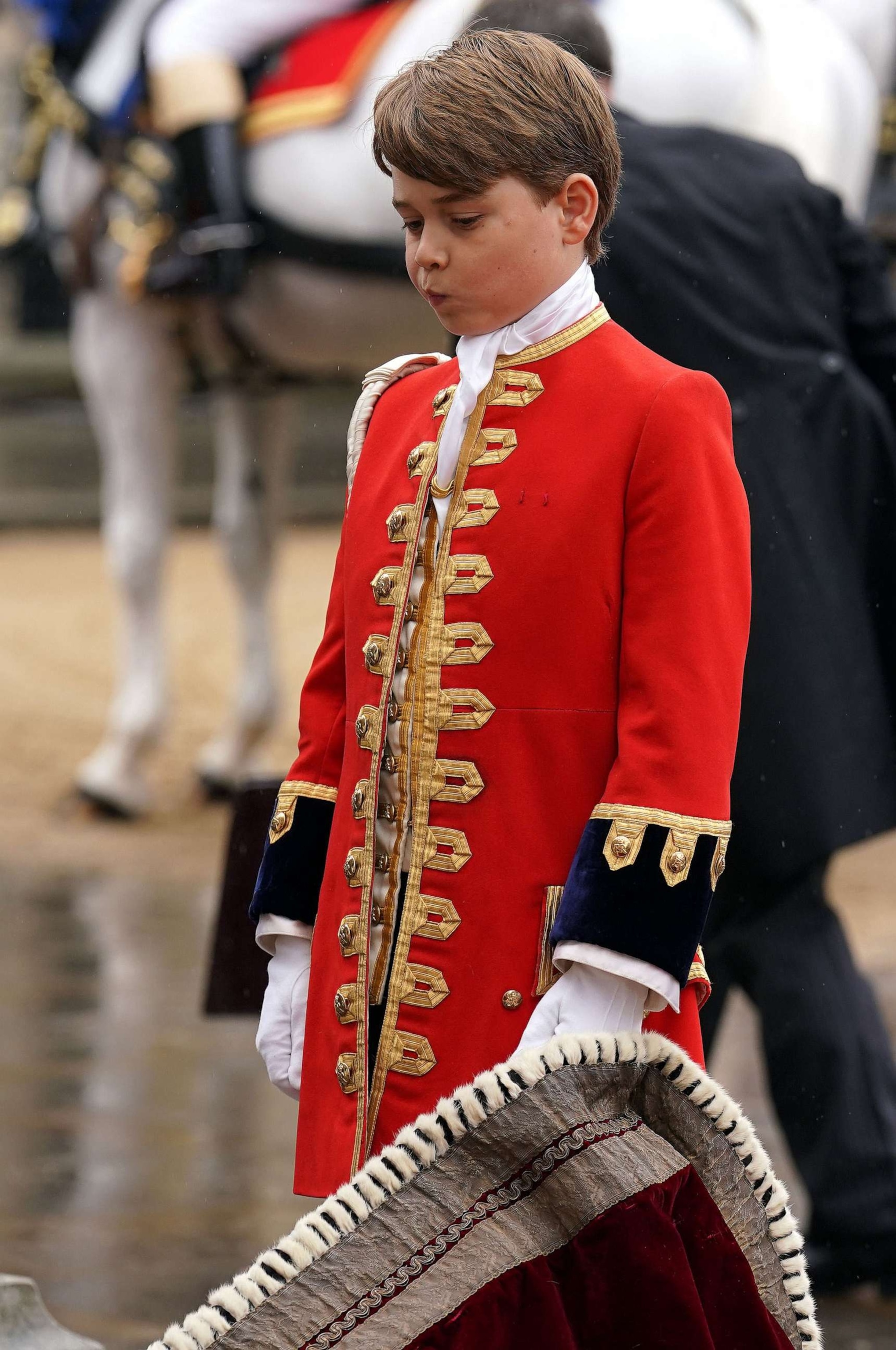 PHOTO: Britain's Prince George of Wales holds the robe of Britain's King Charles III at Westminster Abbey, in central London on May 6, 2023, during the Coronation.