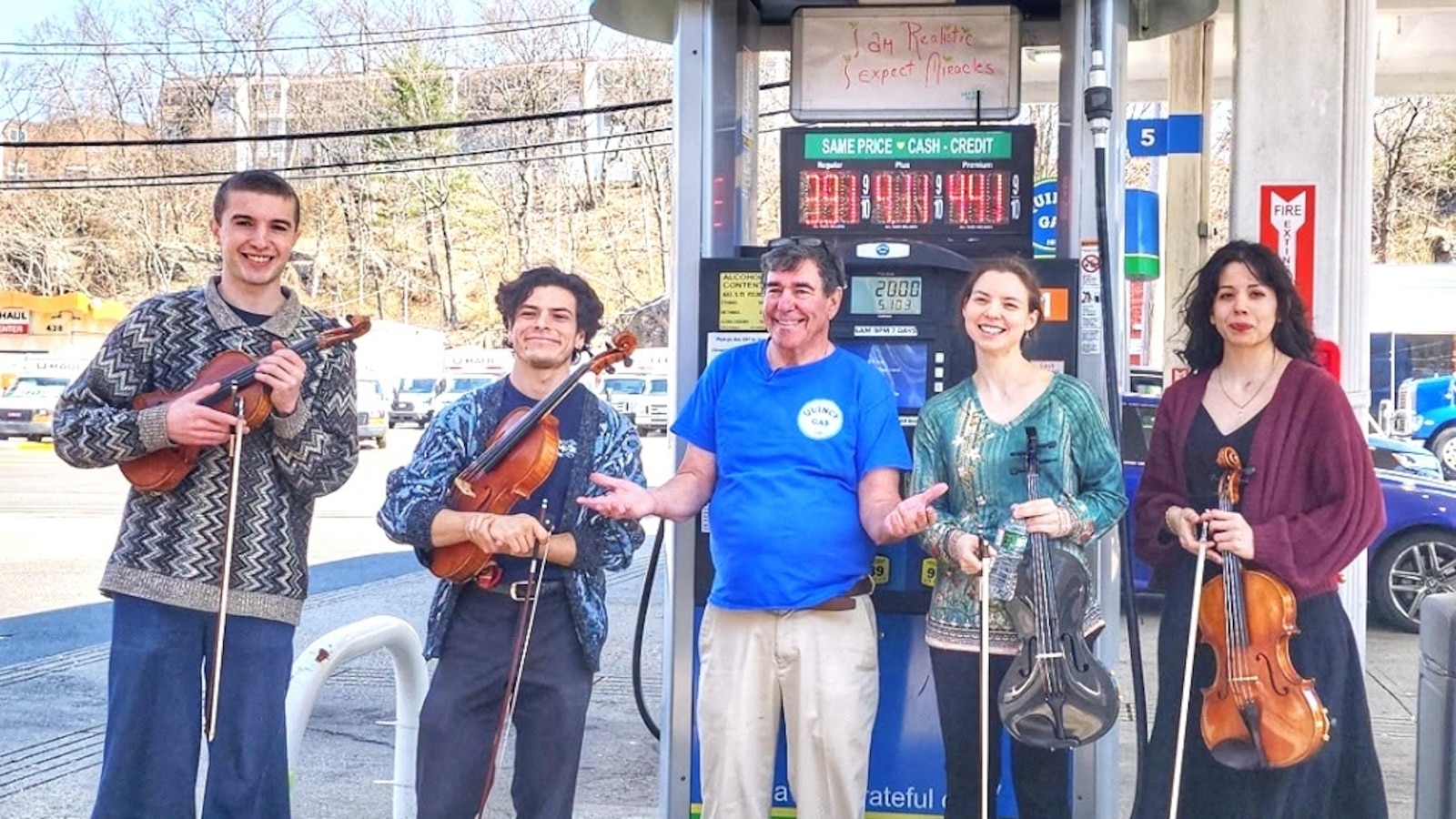 A rotation of violists are performing live music for customers at Quincy Gas station in Quincy, Massachusetts.