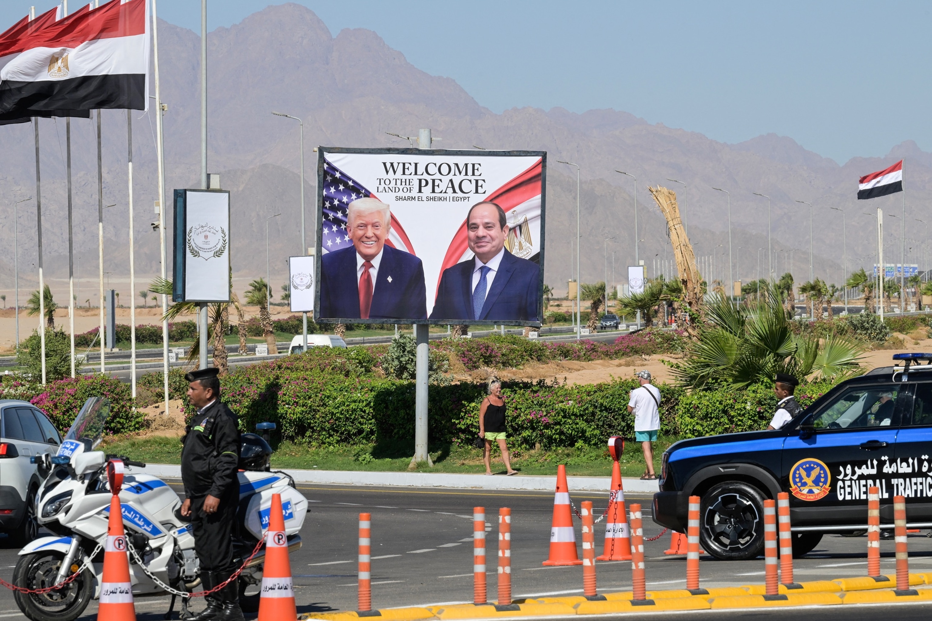 PHOTO: Tourists take pictures in front of a billboard bearing the portraits of President Donald Trump and Egyptian President Abdel Fattah al-Sisi in the Egyptian Red Sea resort town of Sharm el-Sheikh on Oct. 13, 2025.