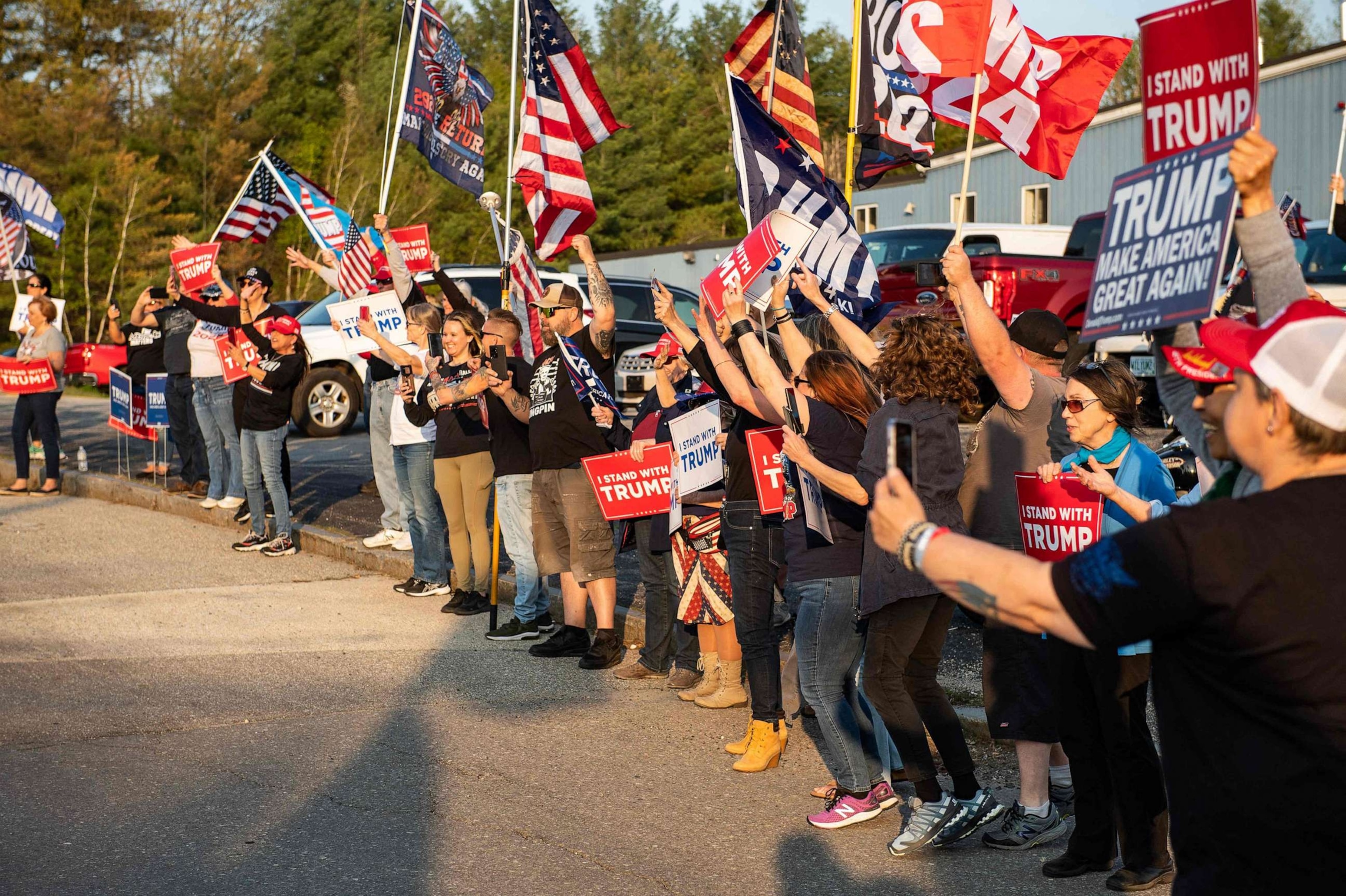 PHOTO: Supporters of former President and 2024 Presidential hopeful Donald Trump cheer as his motorcade drives by outside Manchester airport in Manchester, New Hampshire, on May 10, 2023, ahead of his CNN town hall meeting.