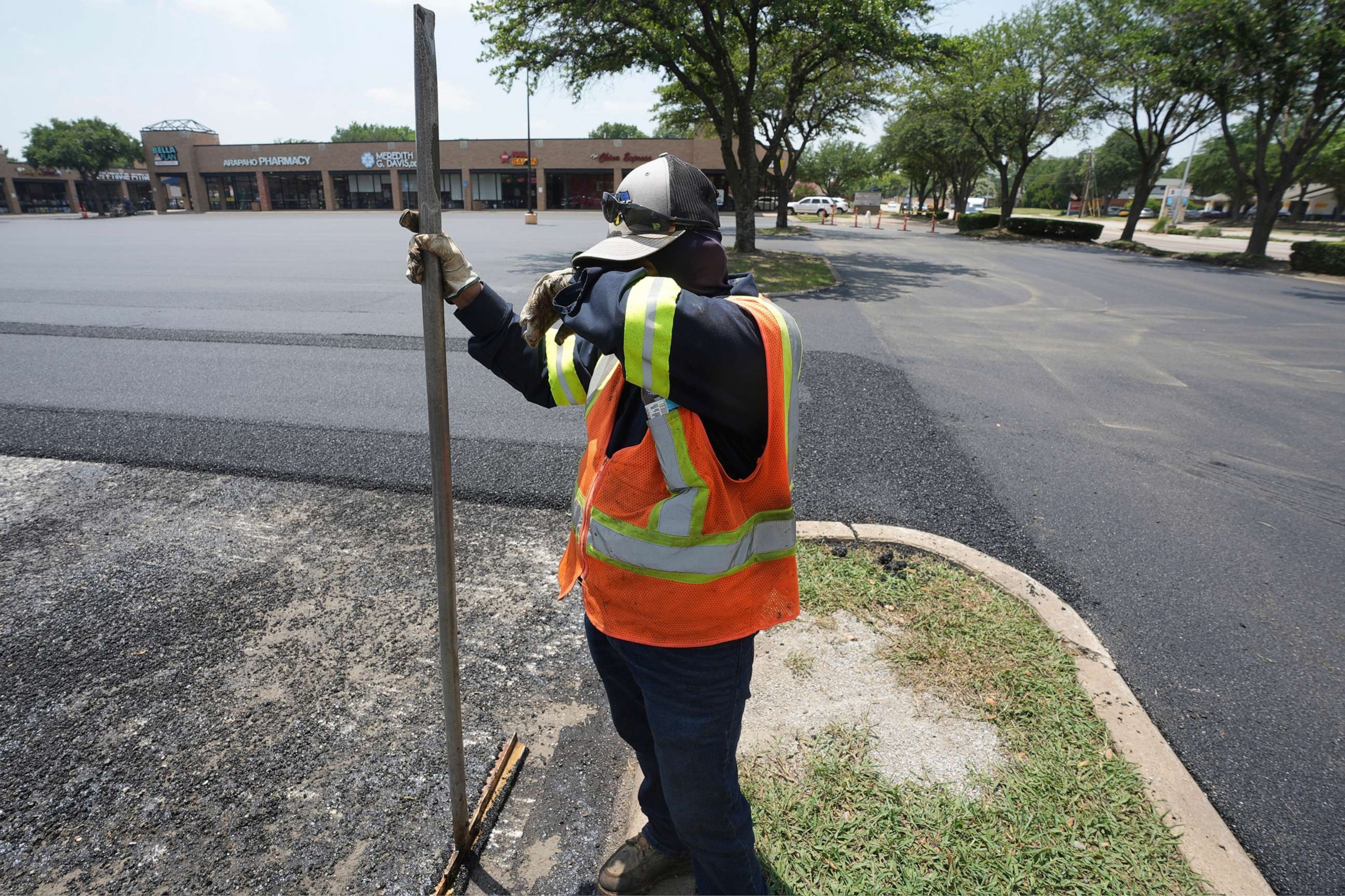 PHOTO: Miguel takes a break from shoveling asphalt during a parking lot resurfacing job in Richardson, Texas, June 20, 2023.