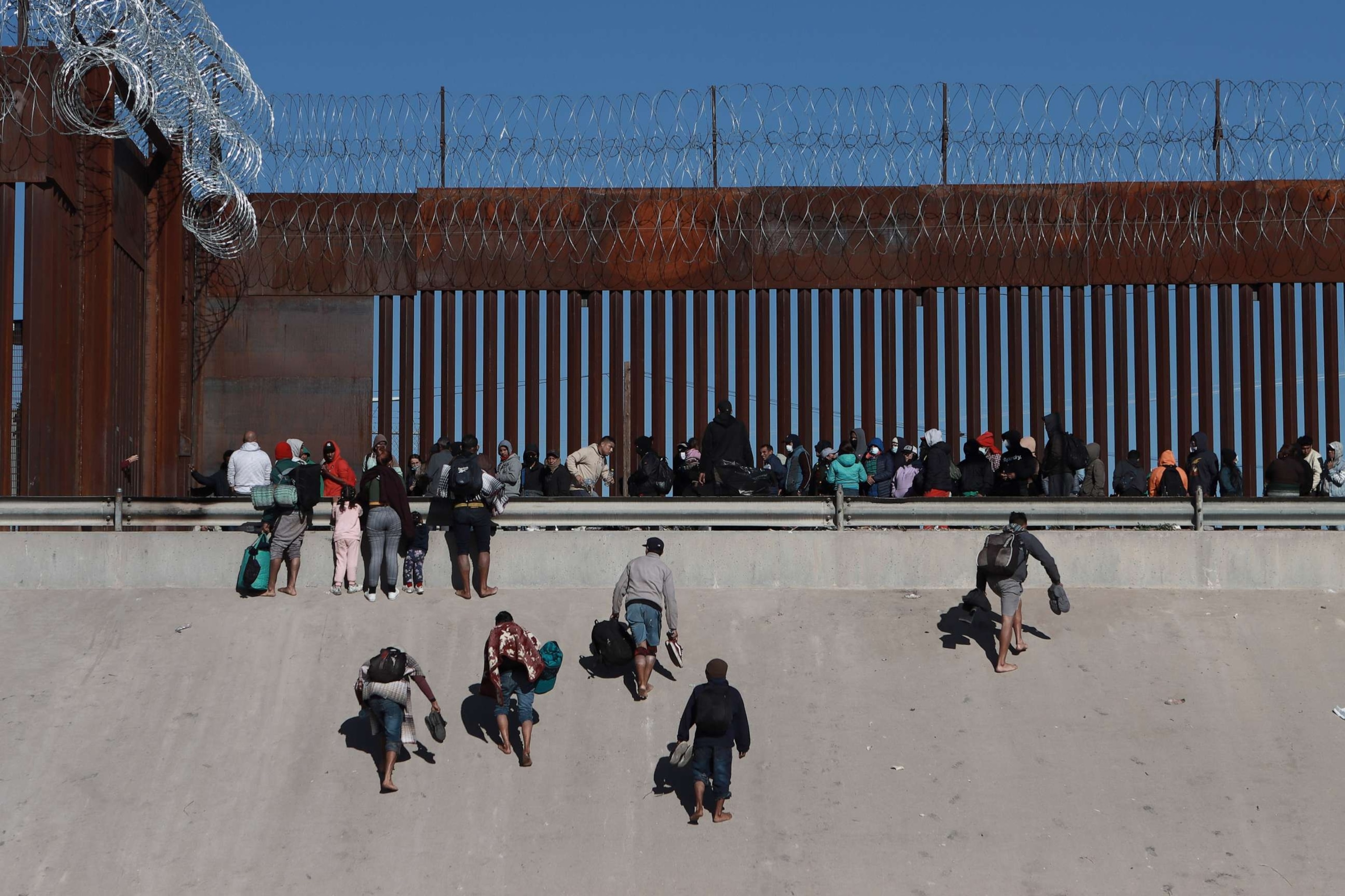 PHOTO: Migrants approach the border wall in Ciudad Juarez, Mexico, on Dec. 21, 2022, on the other side of the border from El Paso, Texas.