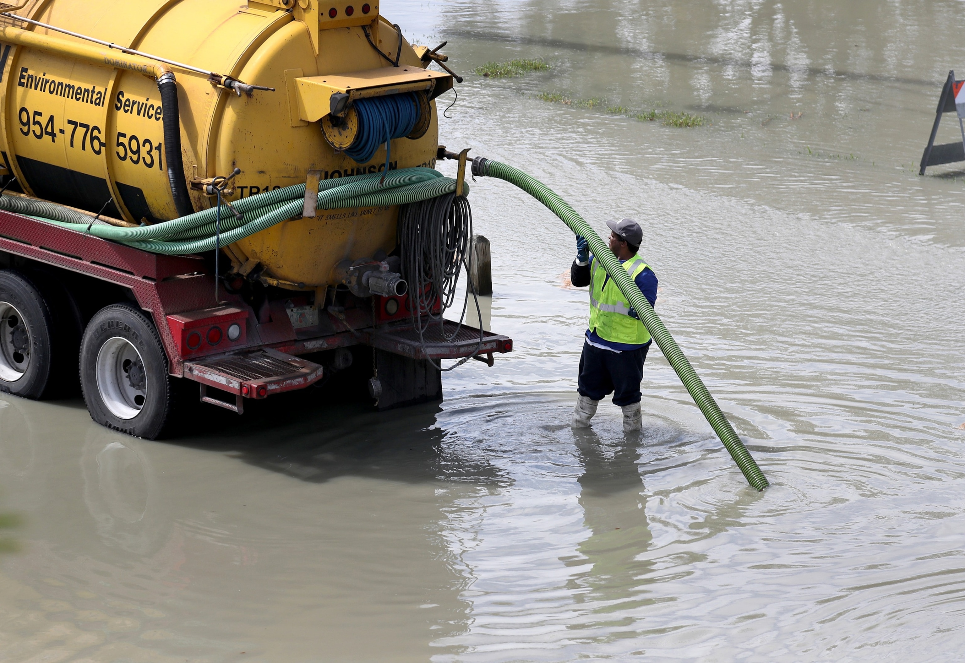 PHOTO: A worker uses a  vacuum truck to suck up sewer water that flooded the area at George English park after a sewer main break broke on February 24, 2020 in Fort Lauderdale, Florida.