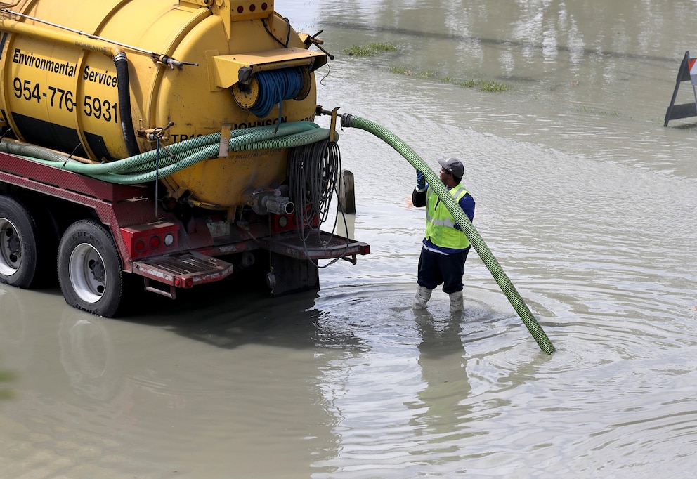 PHOTO: A worker uses a vacuum truck to suck up sewer water that flooded the area at George English park after a sewer main break broke on February 24, 2020 in Fort Lauderdale, Florida.