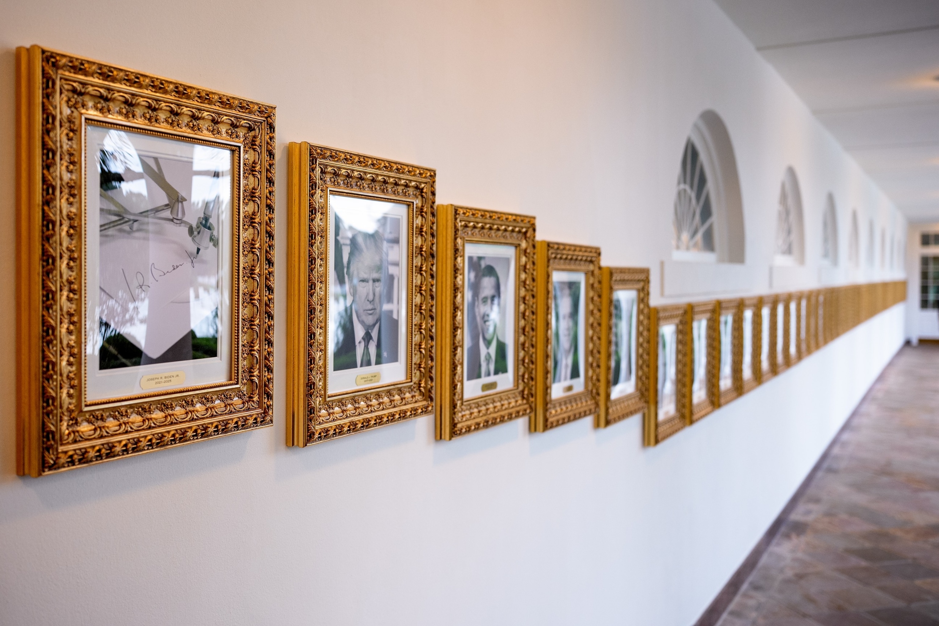 PHOTO: Framed portraits of President Donald Trump flank an image of former President Joe Biden's signature and an autopen along "The Presidential Walk of Fame" on the wall of the colonnade outside of the Oval Office at the White House, Sept. 25, 2025.