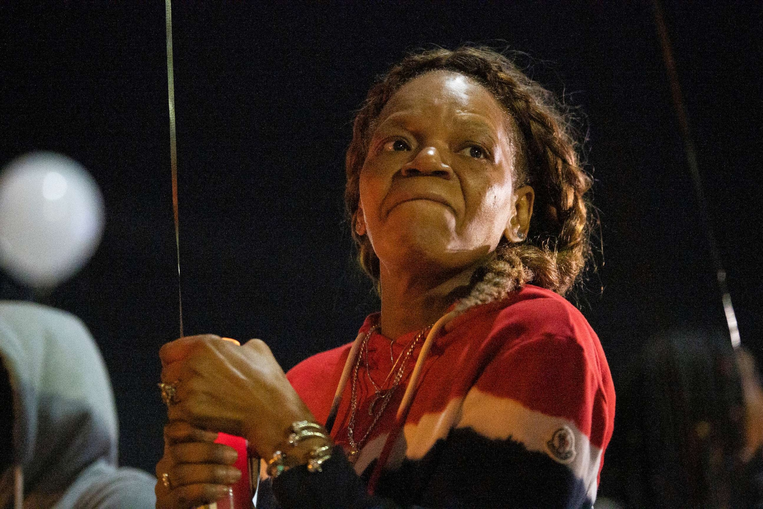 PHOTO: In this Nov. 6, 2020, file photo, the mother of Karon Hylton holds a candle as friends and family gather for a vigil in Hylton's memory two weeks after he was involved in a fatal traffic collision in Washington, D.C.