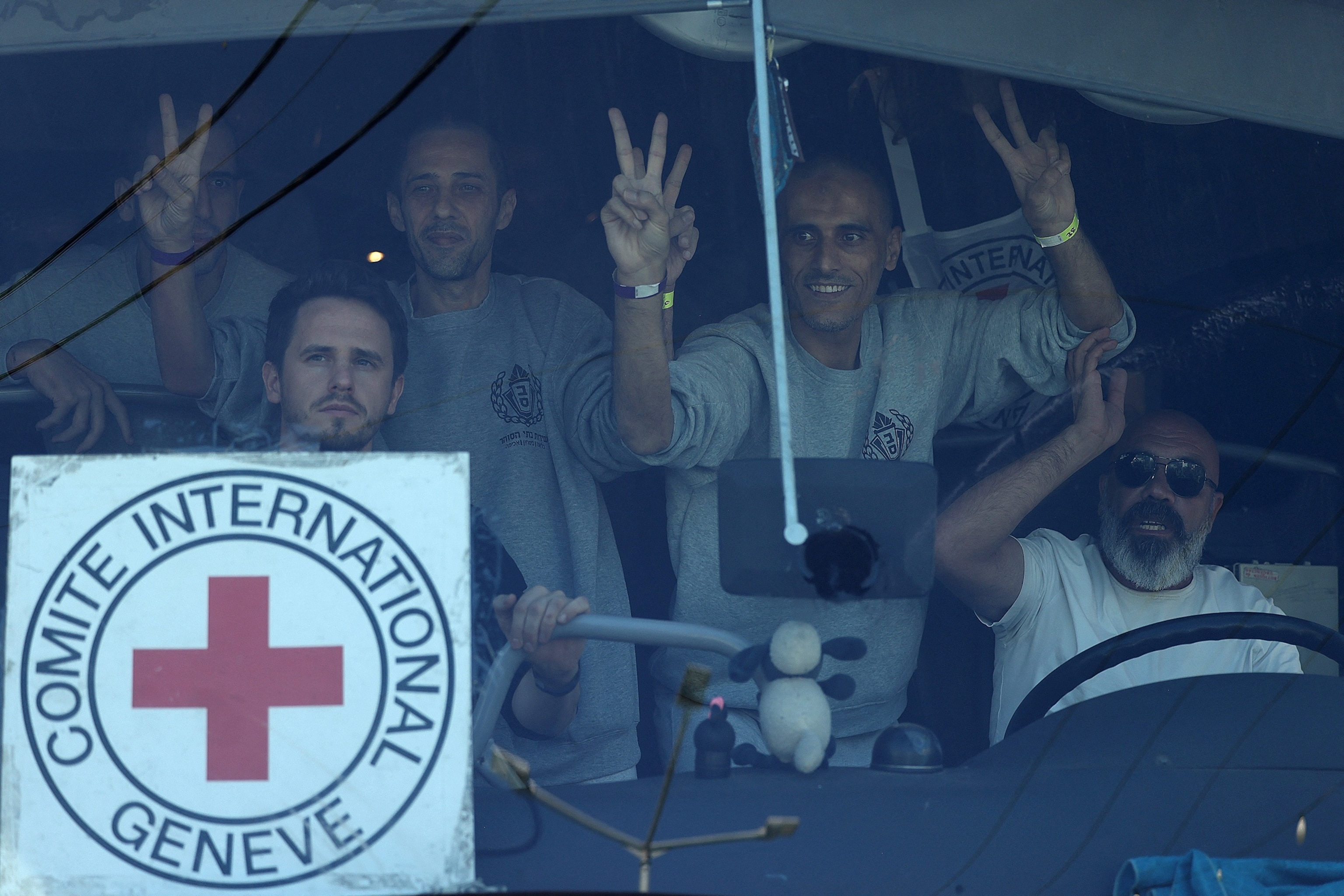 PHOTO: Palestinian men gesture from inside a bus after being released from the Ofer military prison located between Ramallah and Beitunia in the occupied West Bank on October 13, 2025.