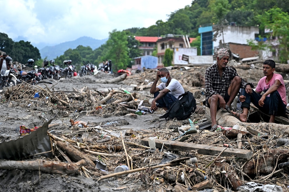 PHOTO: Residents sit beside debris as they salvage belongings following flash floods at Devighat in Nepal's Nuwakot district,  August 31, 2026. 