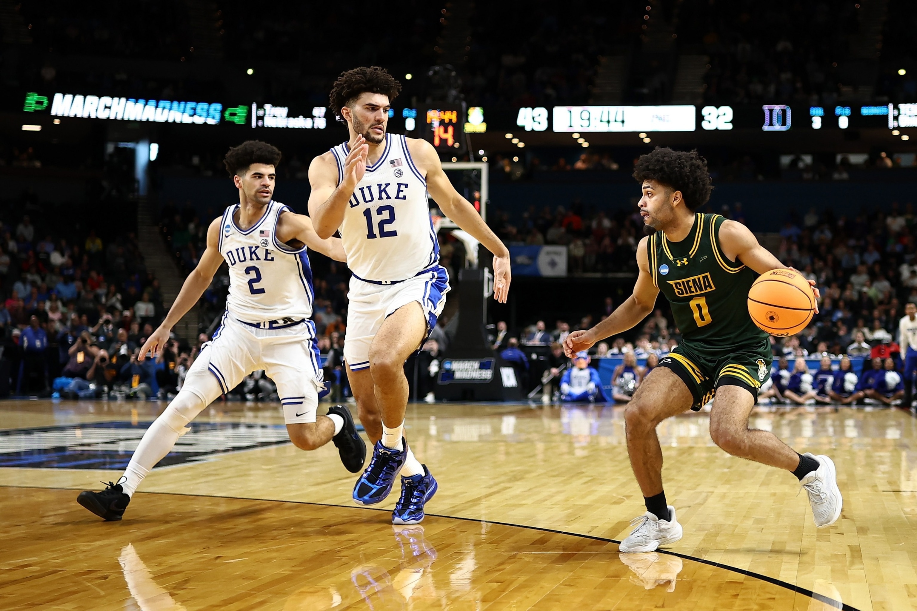 PHOTO: Cayden Boozer and Cameron Boozer of the Duke Blue Devils defend against Justice Shoats of the Siena Saints during the second half of the 2026 NCAA Men's Basketball Tournament, on March 19, 2026, in Greenville, South Carolina.