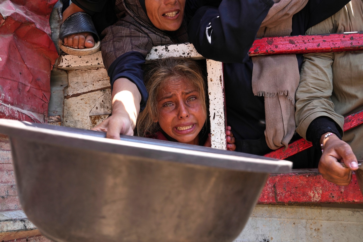 Palestinians struggle to get donated food at a community kitchen, in Gaza City, northern Gaza Strip, July 26, 2025.