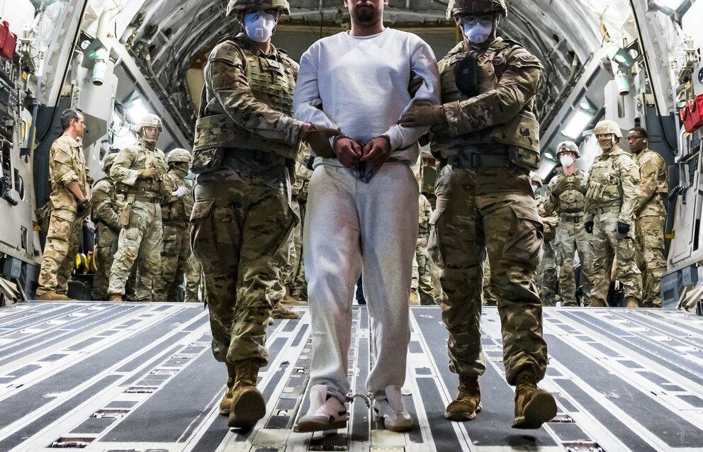 PHOTO: U.S. military personnel escort an alleged member of the gang Venezuelan Tren de Aragua and the MS-13 gang to be imprisoned at the CECOT prison, at the El Salvador International Airport in San Luis Talpa, El Salvador April 12, 2025.