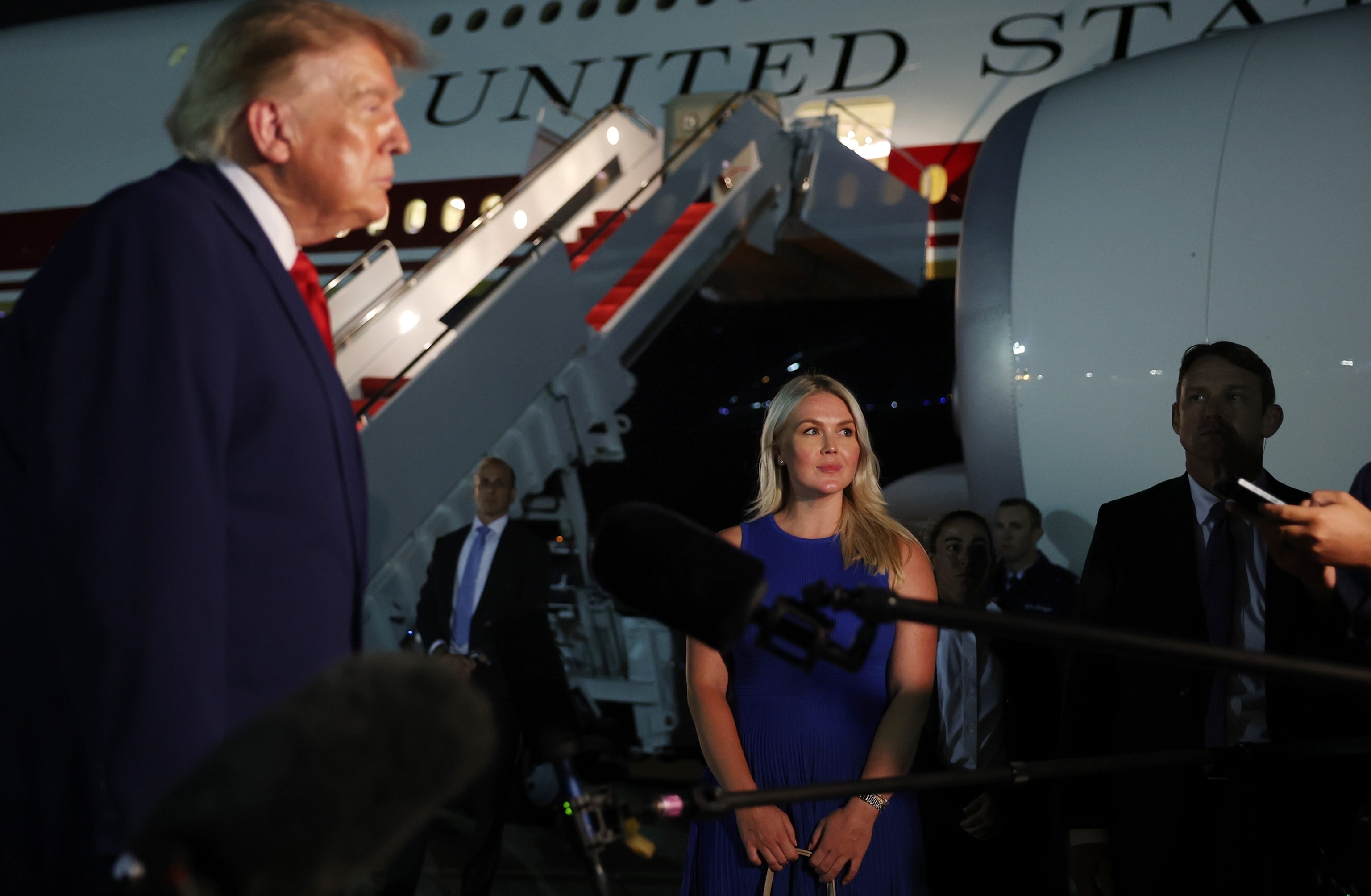 PHOTO: White House Press Secretary Karoline Leavitt looks on as President Donald Trump speaks to reporters after stepping off Air Force One on Aug. 11, 2026, at Joint Base Andrews, Maryland.