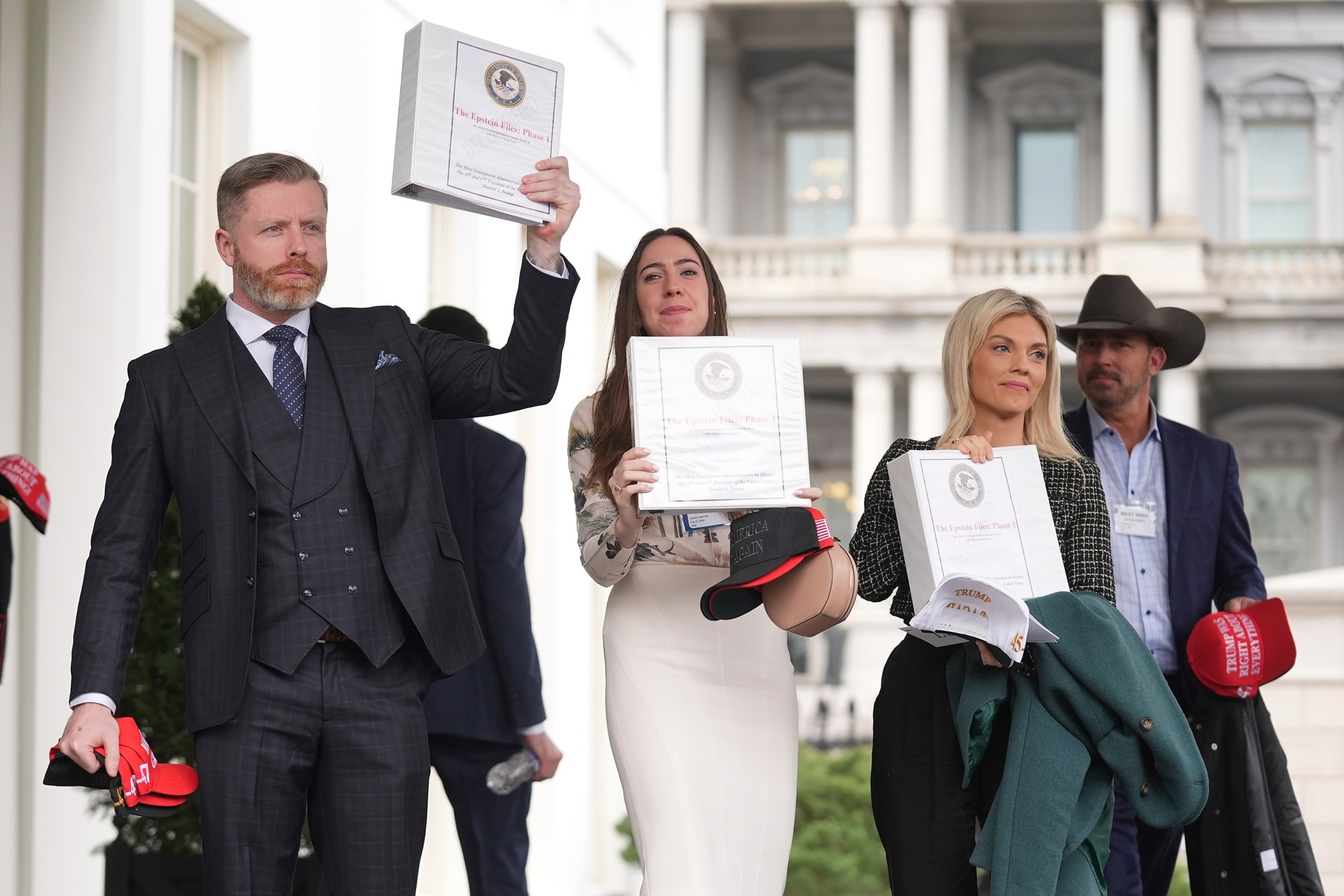 PHOTO: Conservative political commentators and influencers hold up binders with a cover titled "The Epstein Files: Phase 1," with Jack Posobiec at the White House, Feb. 27, 2025, in Washington.