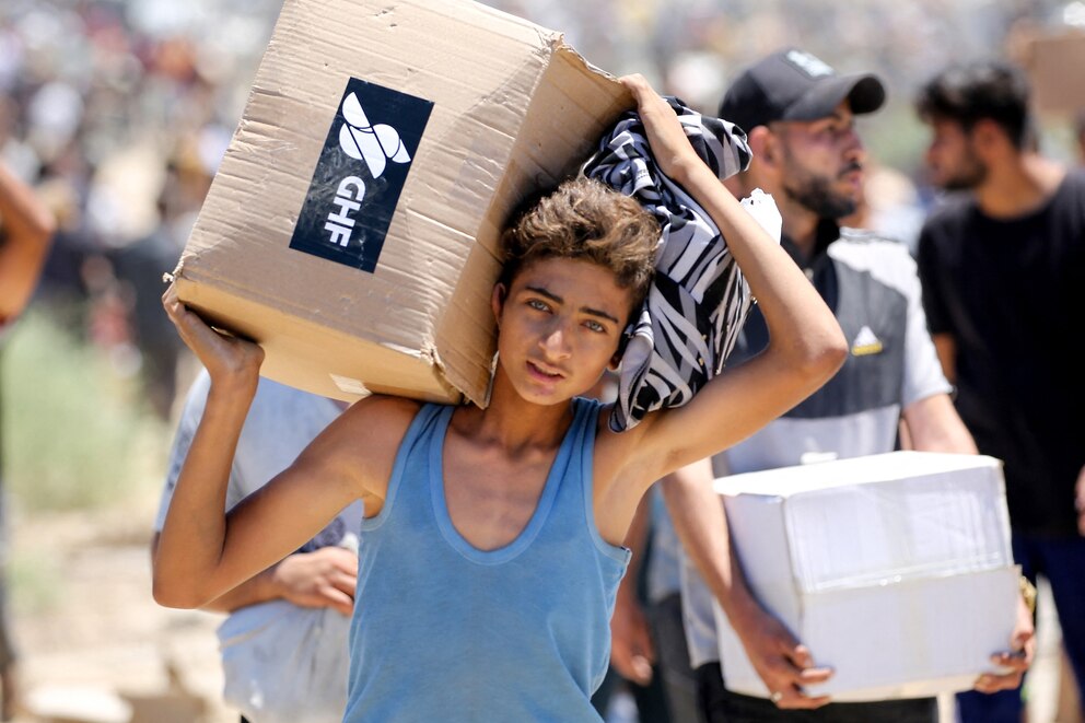 PHOTO: A boy carries a box of relief supplies from the Gaza Humanitarian Foundation (GHF), as displaced Palestinians return from an aid distribution centre in the central Gaza Strip on May 29, 2025. 