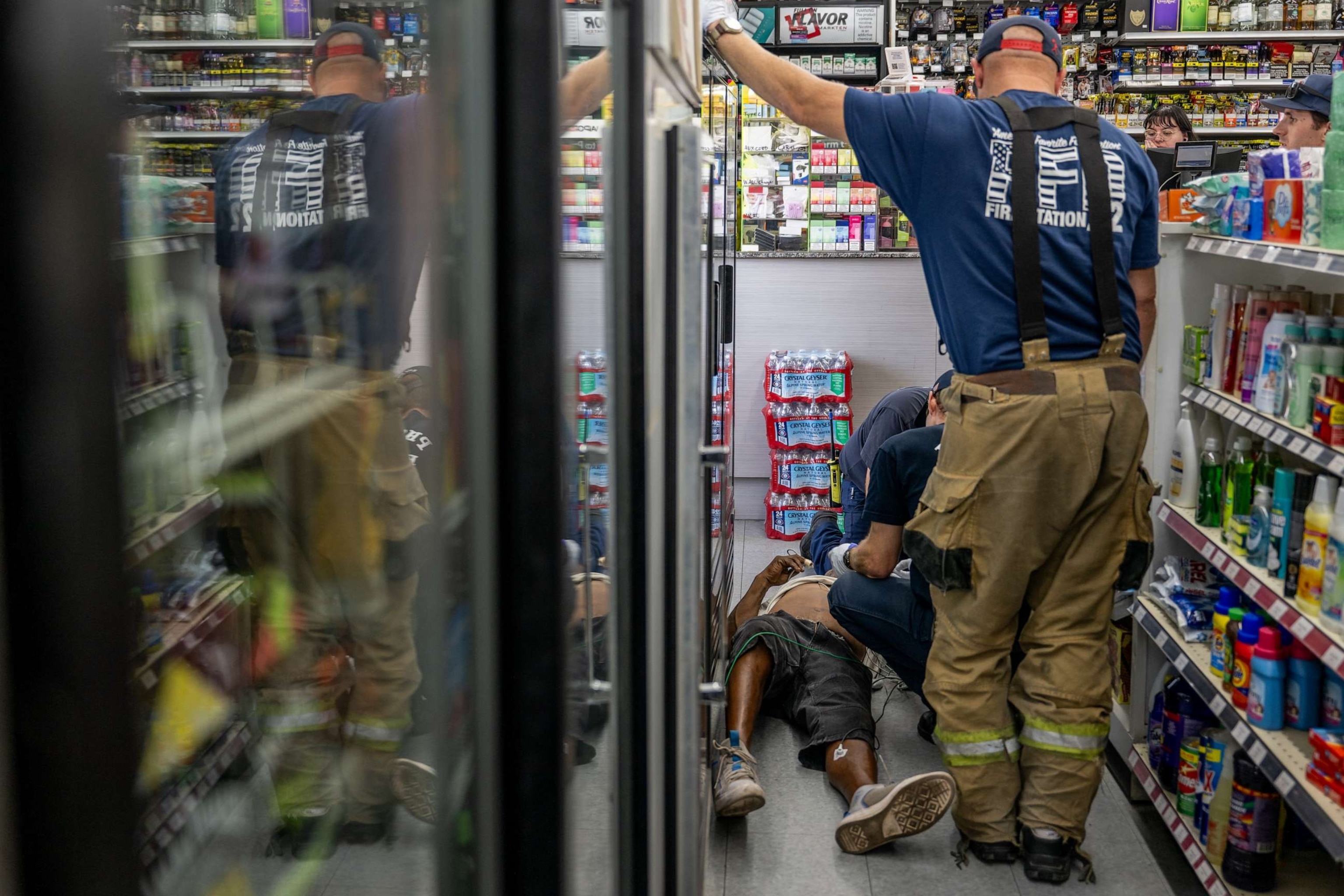 PHOTO: A person receives medical attention after collapsing in a convenience store on July 13, 2023 in Phoenix.