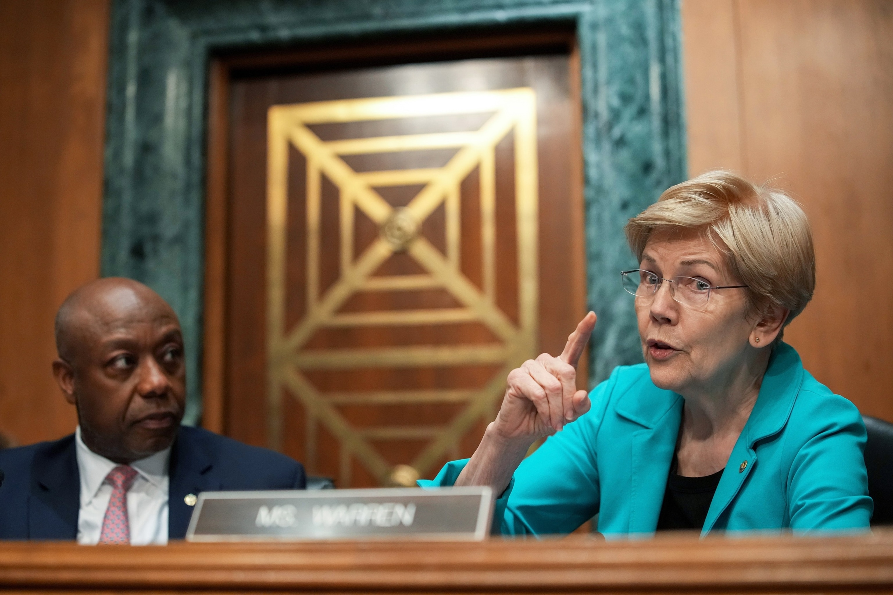PHOTO:In this April 21, 2026, file photo, Committee Chairman Sen. Tim Scott looks on as ranking member Sen. Elizabeth Warren (D-MA) speaks during a Senate Committee on Banking, Housing, and Urban Affairs meeting in Washington, D.C.