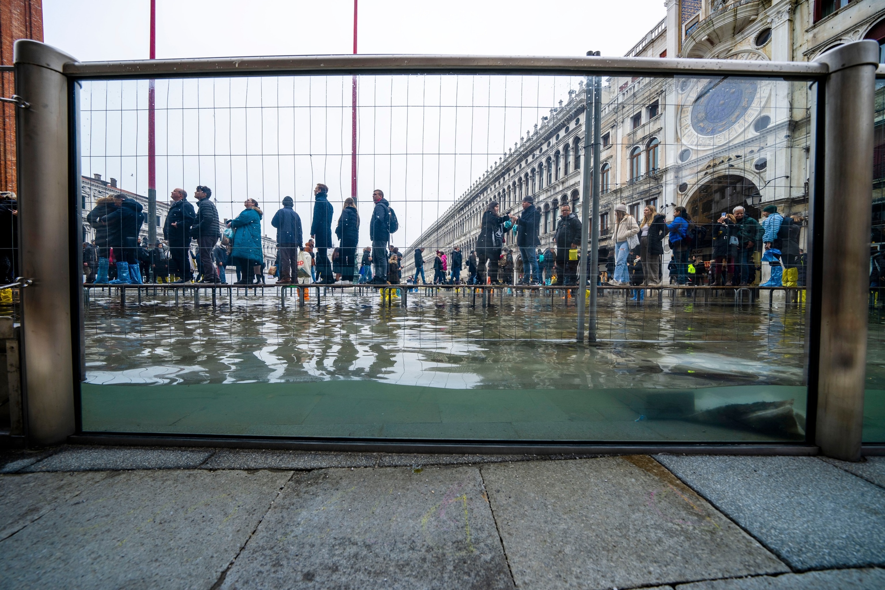 PHOTO: In this Dec. 10, 2022, file photo, tourists and residents walk on catwalks during a sea tide of around 38.18 inches, to cross a flooded St. Mark's Square in Venice, northern Italy.