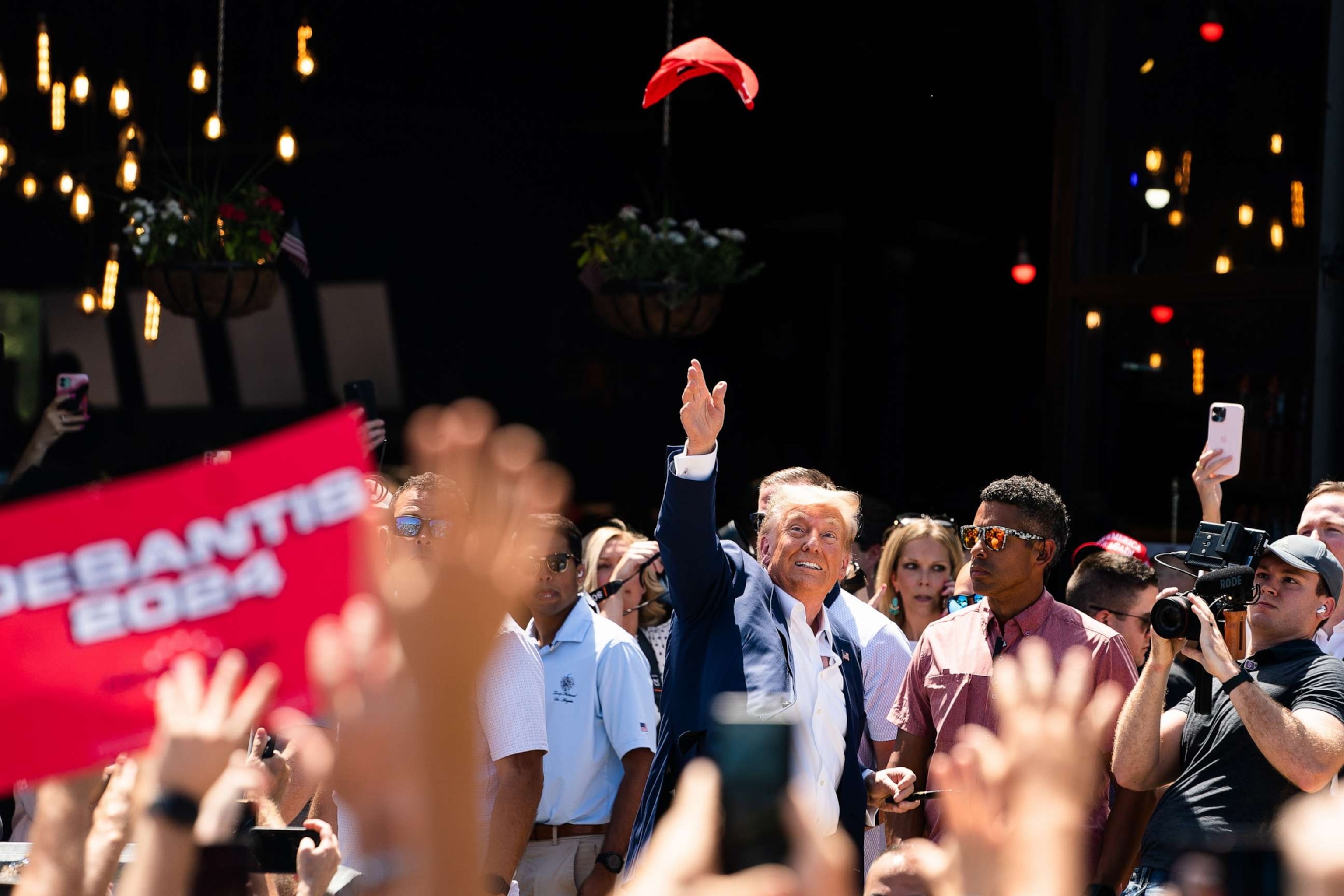 PHOTO: Former President Donald Trump tosses a hat in the air while supporters cheer for him during the 2023 Iowa State Fair at the Iowa State Fair Grounds, Aug. 12, 2023, in Des Moines, Iowa.