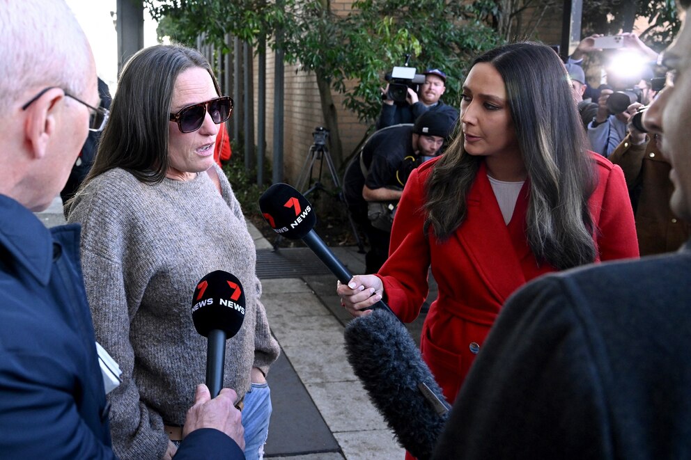 PHOTO: Members of the media talk to a friend of Erin Patterson as she leaves the Latrobe Valley Magistrates' Court in Morwell, where Patterson was found by a jury on July 7, 2025.
