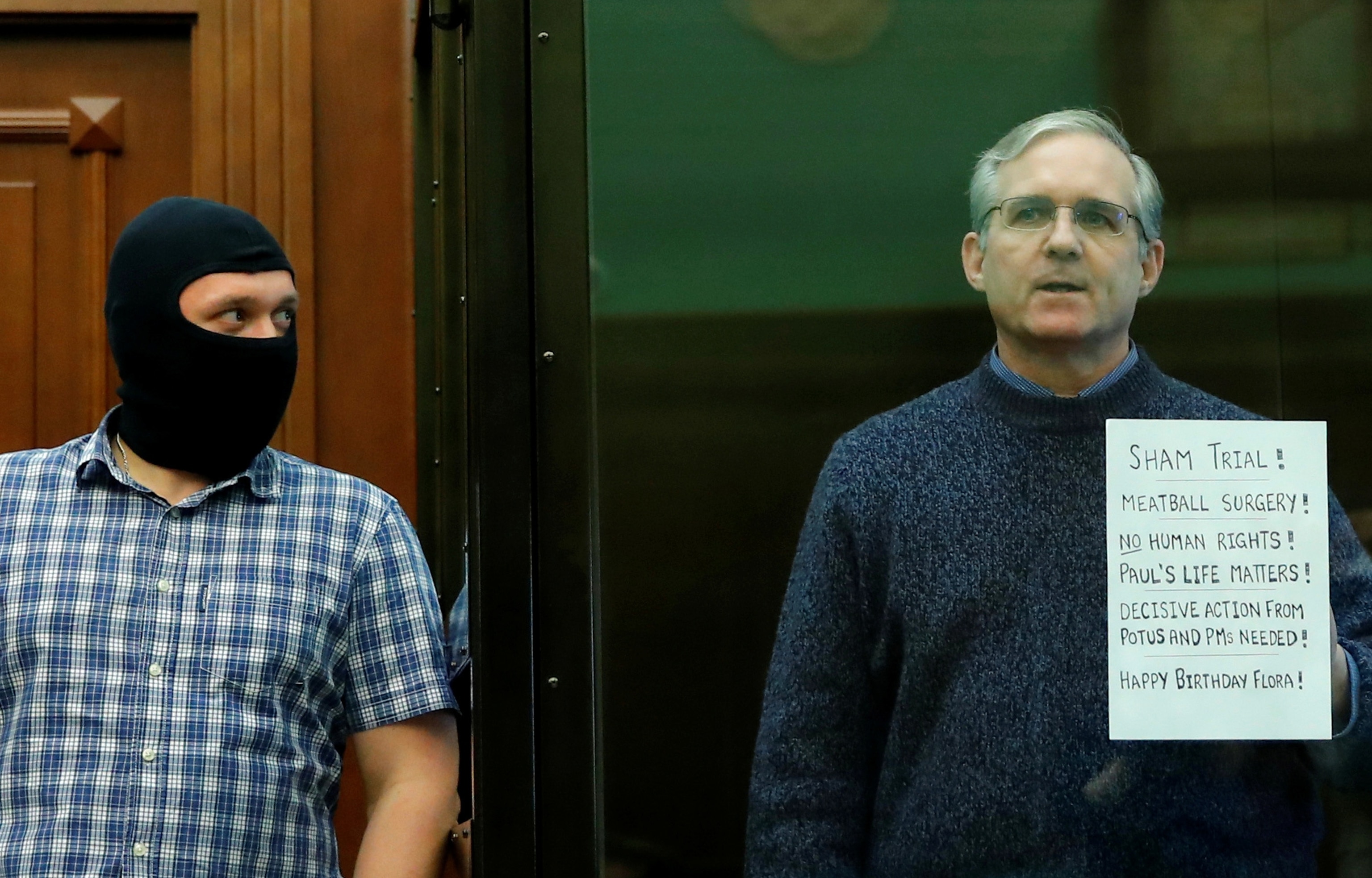 PHOTO: In this June 15, 2020, file photo, former U.S. Marine Paul Whelan, who was detained and accused of espionage, holds a sign as he stands inside a defendants' cage during his verdict hearing in Moscow.