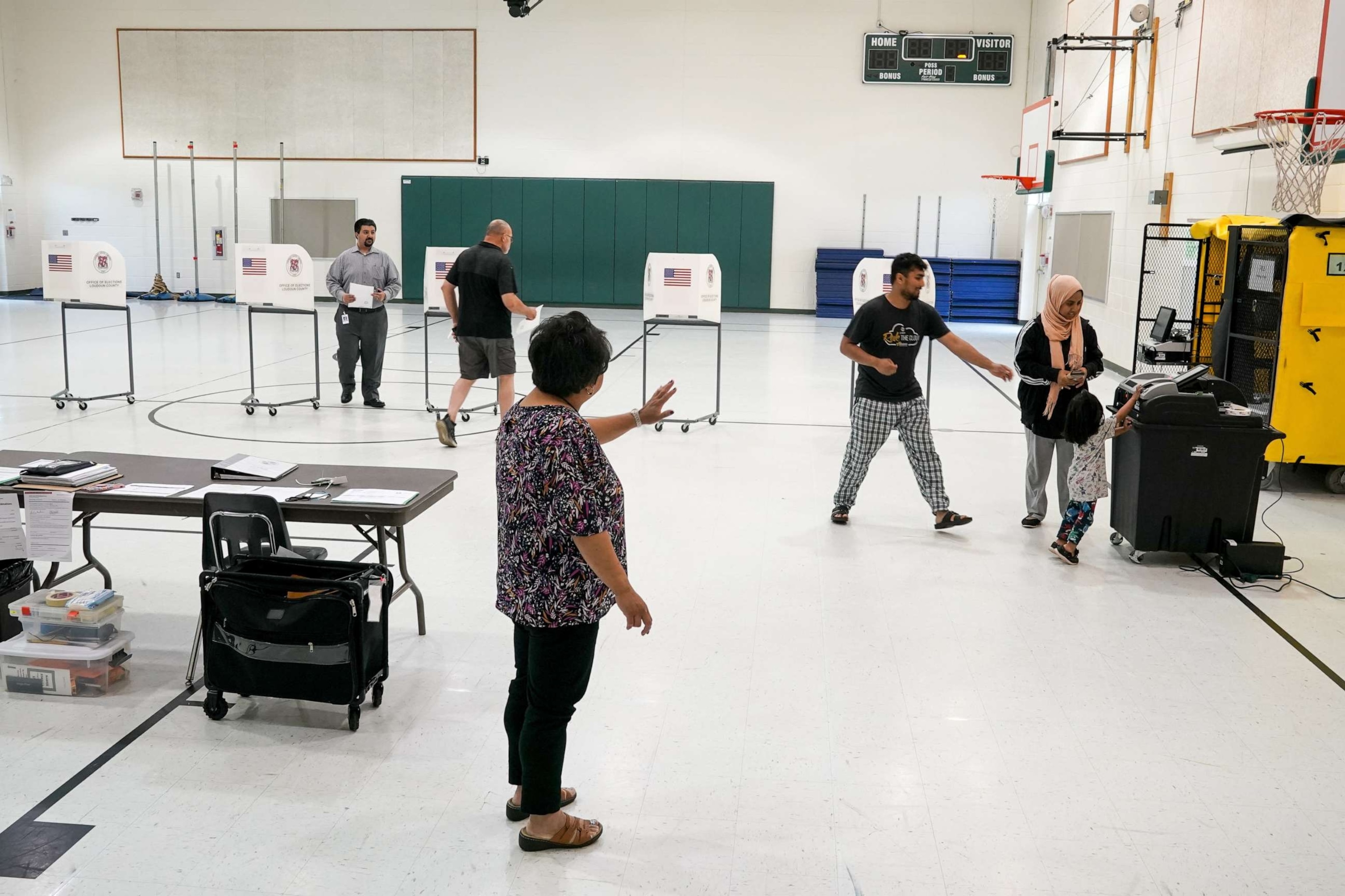 PHOTO: Kristine Kozlowski, C, assistant chief of elections, guides voters through the process as Virginia holds primary elections for all the legislative seats and local races on June 20, 2023, in Sterling, VA.