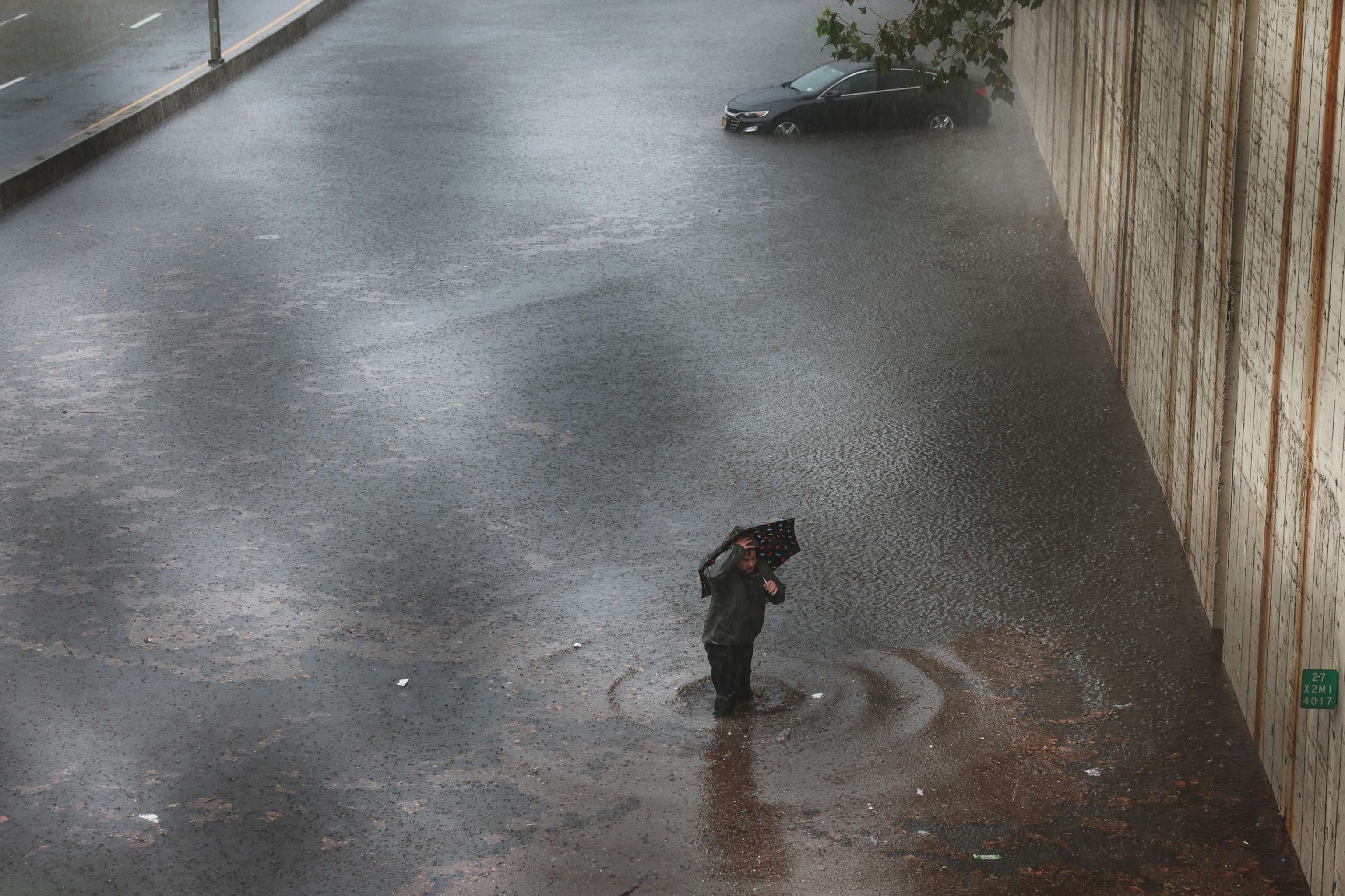 PHOTO: A person walks away from his vehicle after it got stuck in high water on the Prospect Expressway during heavy rain and flooding on Sept. 29, 2023 in New York City.