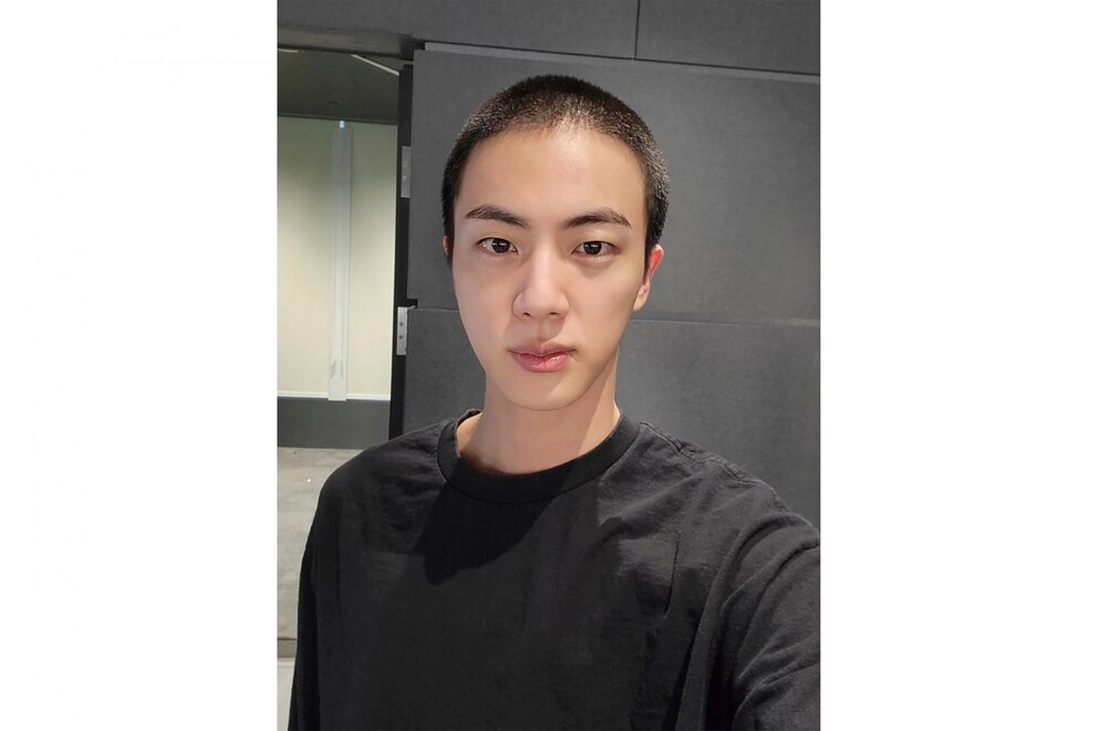 In this photo provided by Weverse, Jin of K-pop band BTS shows off freshly shaved hair on the K-pop social media platform Weverse, which was uploaded Sunday, Dec. 11, 2022, ahead of his upcoming military conscription. Jin, the oldest member of K-pop