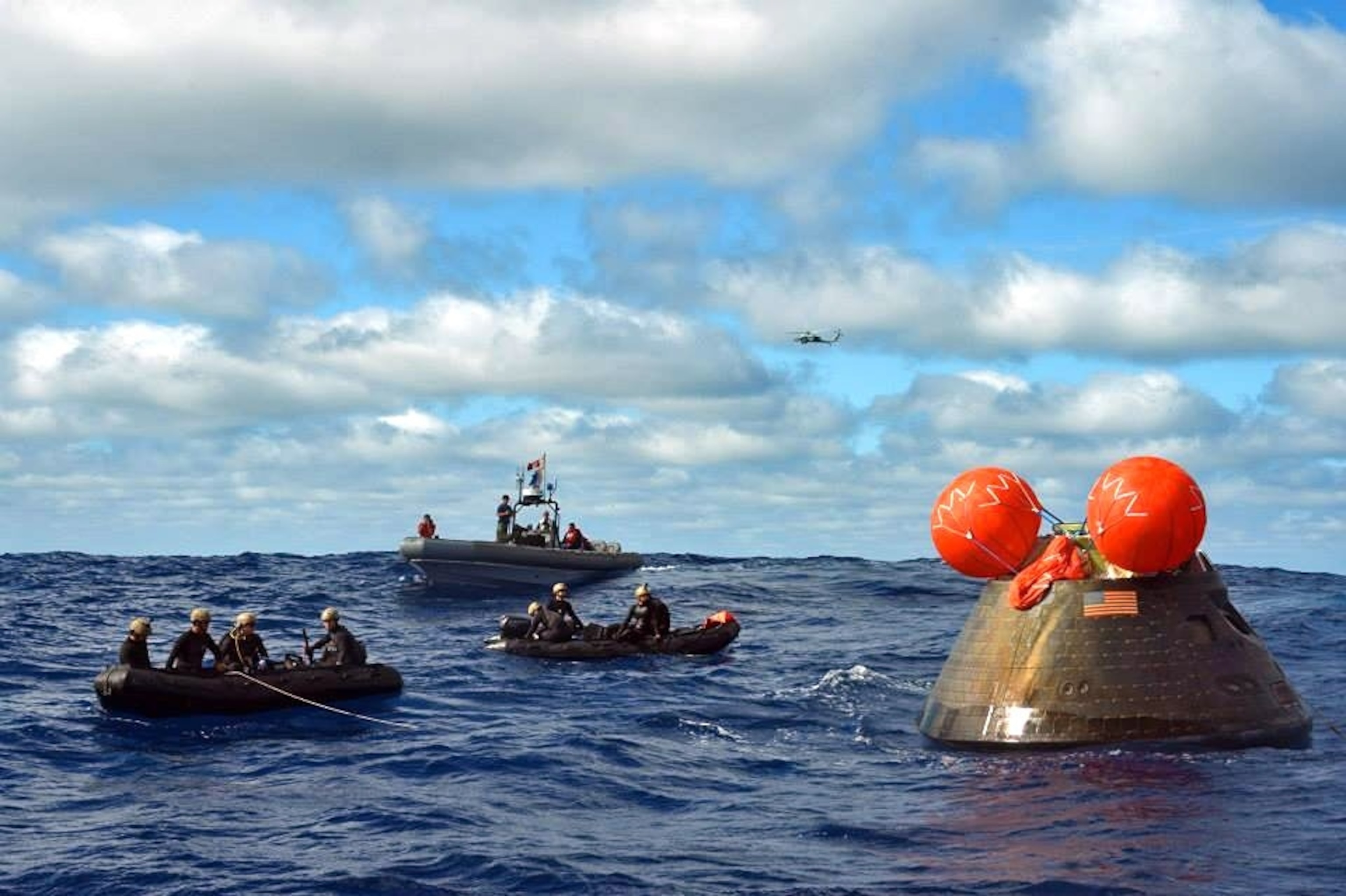 PHOTO: Navy divers attach a towing bridal to the Orion Crew Module during the first Exploration Flight Test (EFT-1) NASA Orion Program following its launch from Cape Canaveral, December 5, 2014 in the Pacific Ocean.