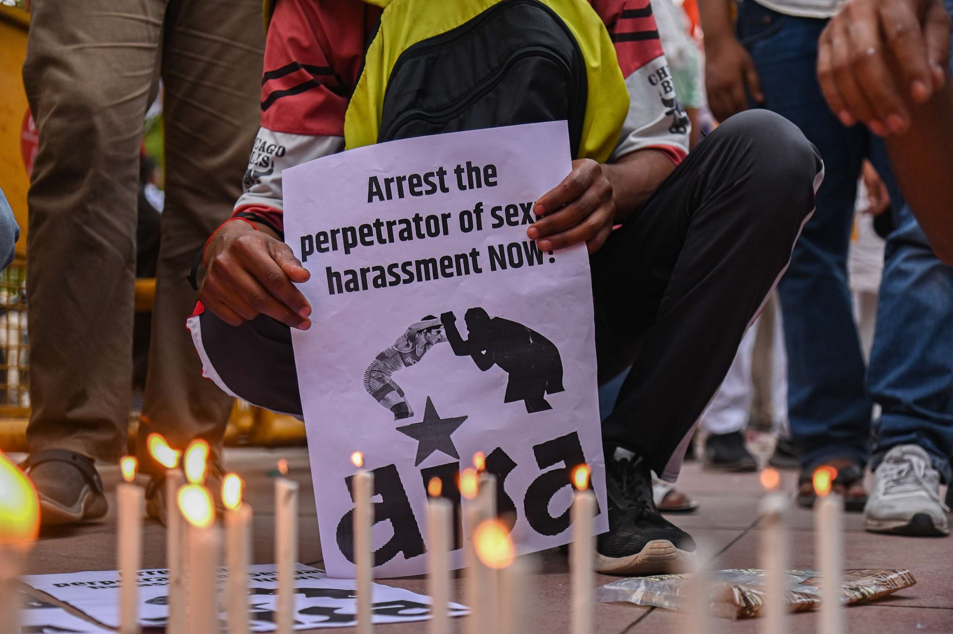 PHOTO: A person holds a placard during a Candlelight March called by India's Top Wrestlers against the allegations of sexual harassment to athletes by the Wrestling Federation of India (WFI) chief, in New Delhi on May 23, 2023.