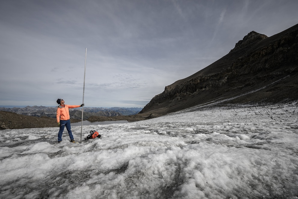 PHOTO: This photograph shows glaciologist and head of 'Glacier Monitoring in Switzerland' (GLAMOS) network Matthias Huss posing with a four-metre-long measuring stake indicating the amount of ice that melted over the past year, Sept. 24, 2026.