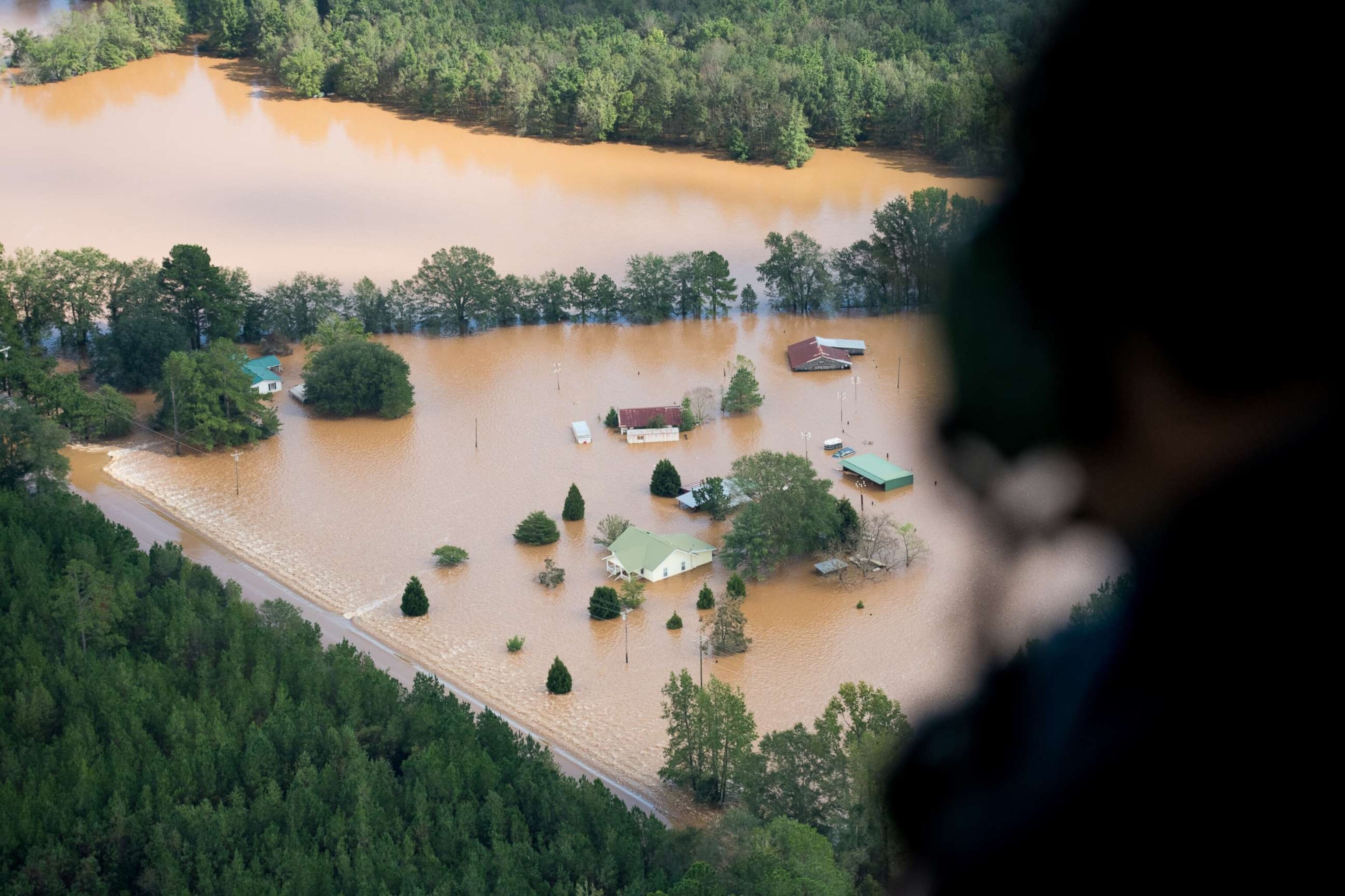 PHOTO: An official looks out a Blackhawk Helicopter at homes surrounded by flood waters due to Hurricane Florence in Conway, S.C., Sept. 17, 2018.