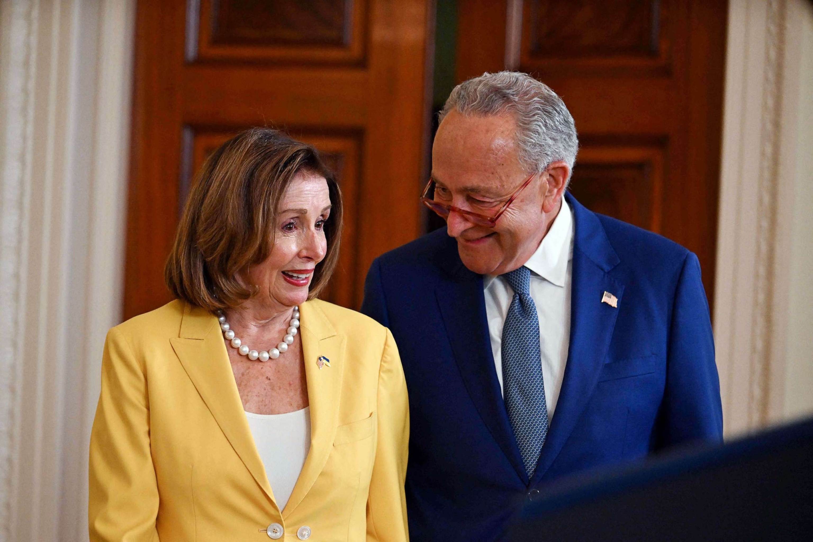 PHOTO: Democratic Representative Nancy Pelosi and Senate Majority Leader Chuck Schumer attend an event on the anniversary of the Inflation Reduction Act in the East Room of the White House in Washington, DC, Aug. 16, 2023.